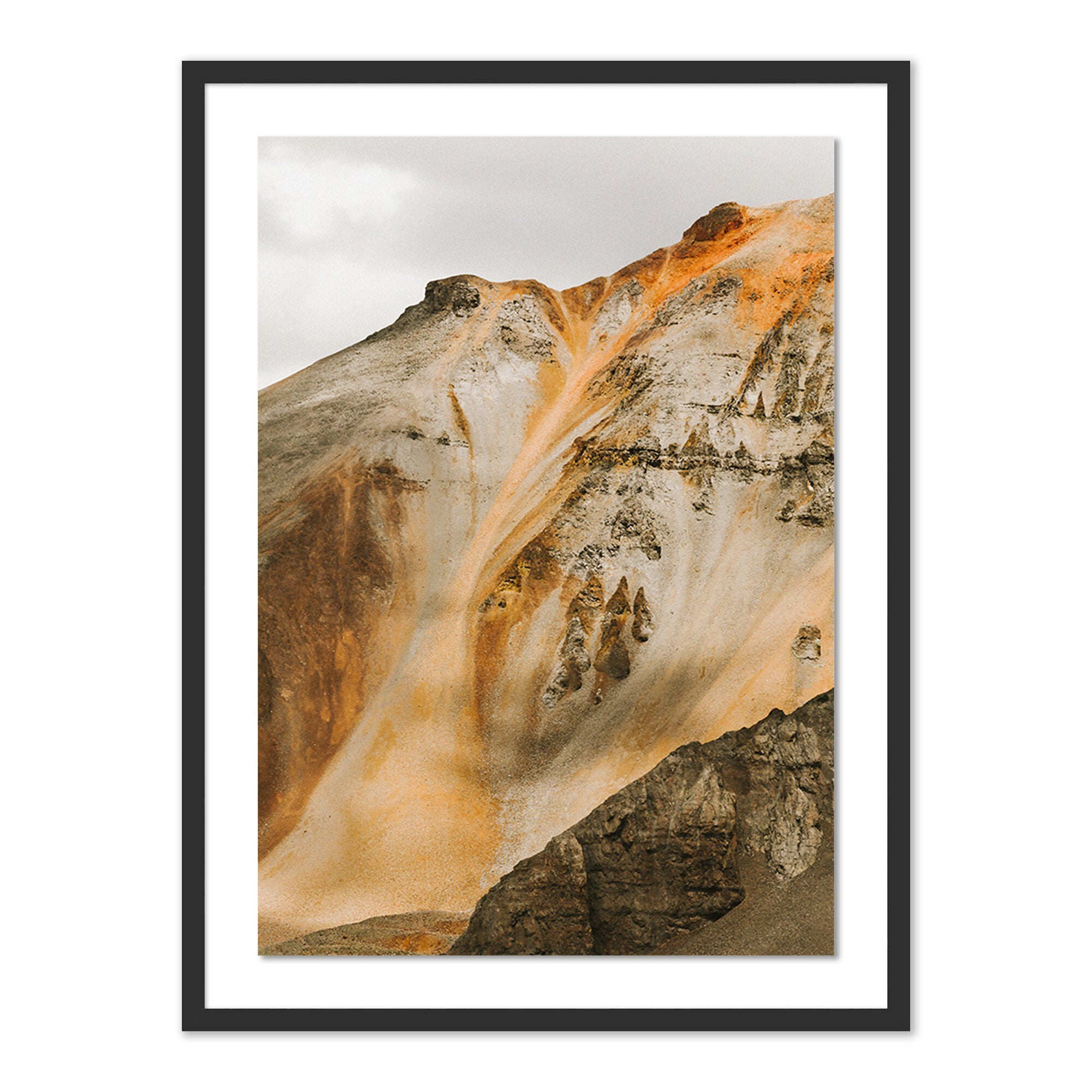 Framed artwork of a mountain landscape with warm colors.