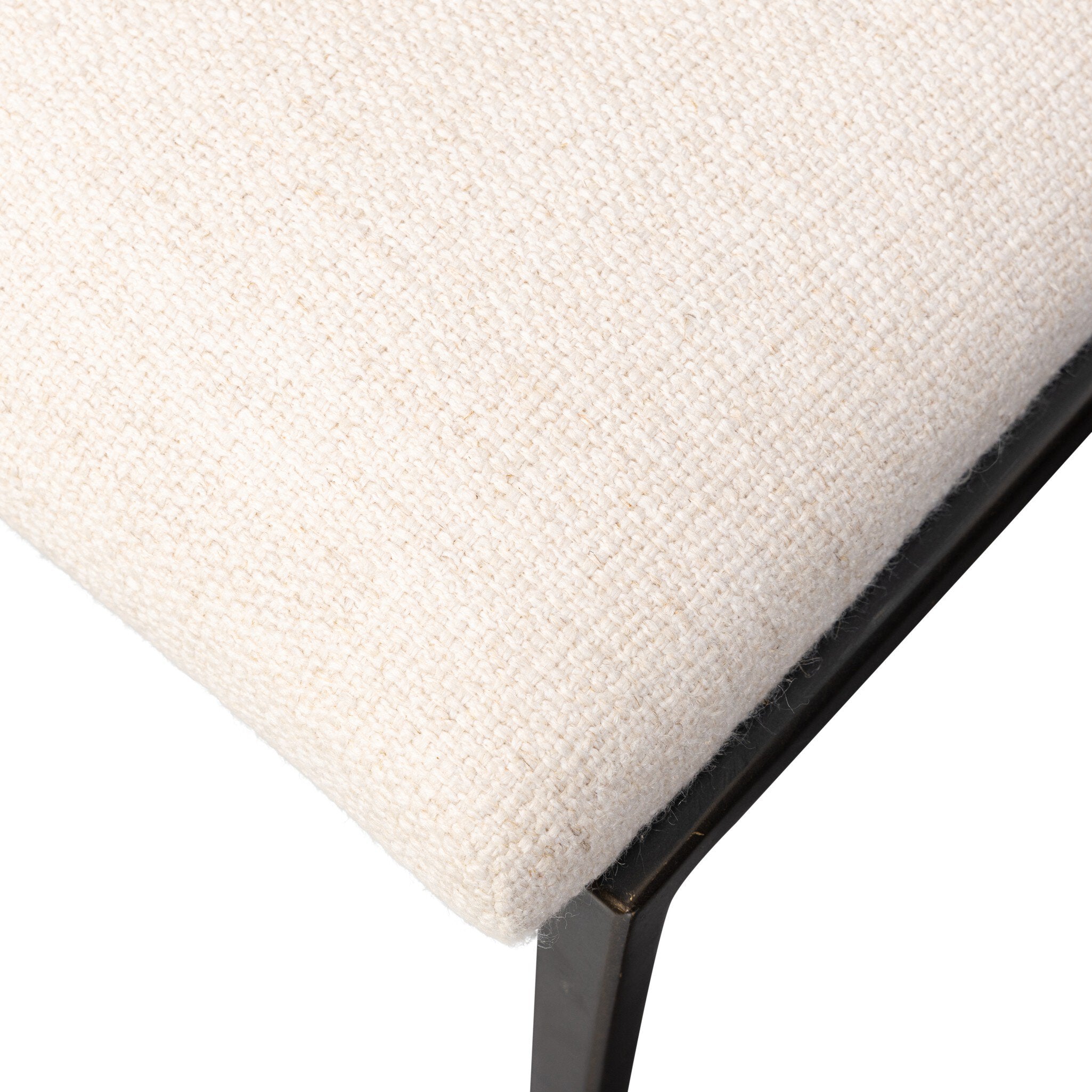 Close-up of a textured beige chair seat with a black metal frame on a white background