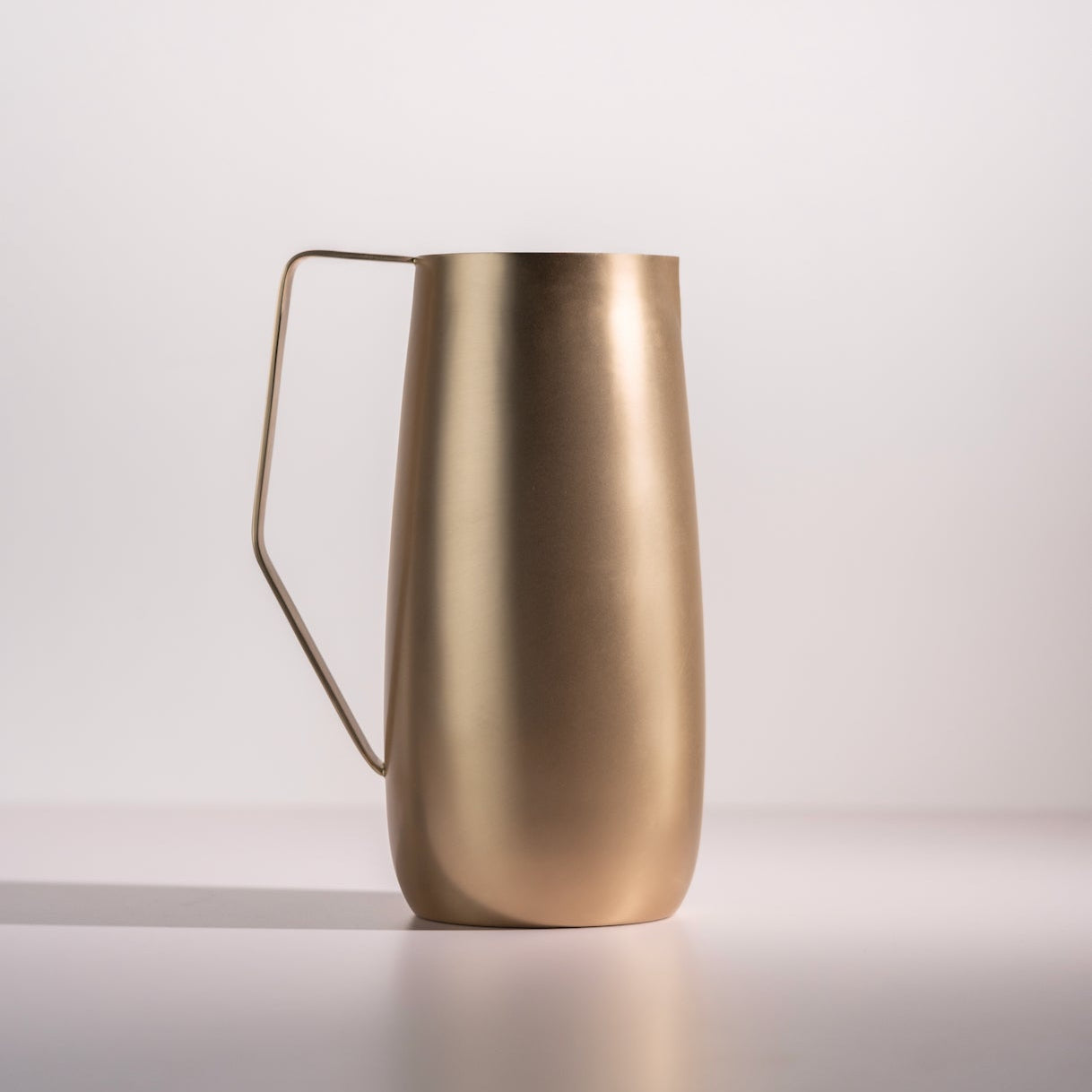 Gold pitcher on a white background