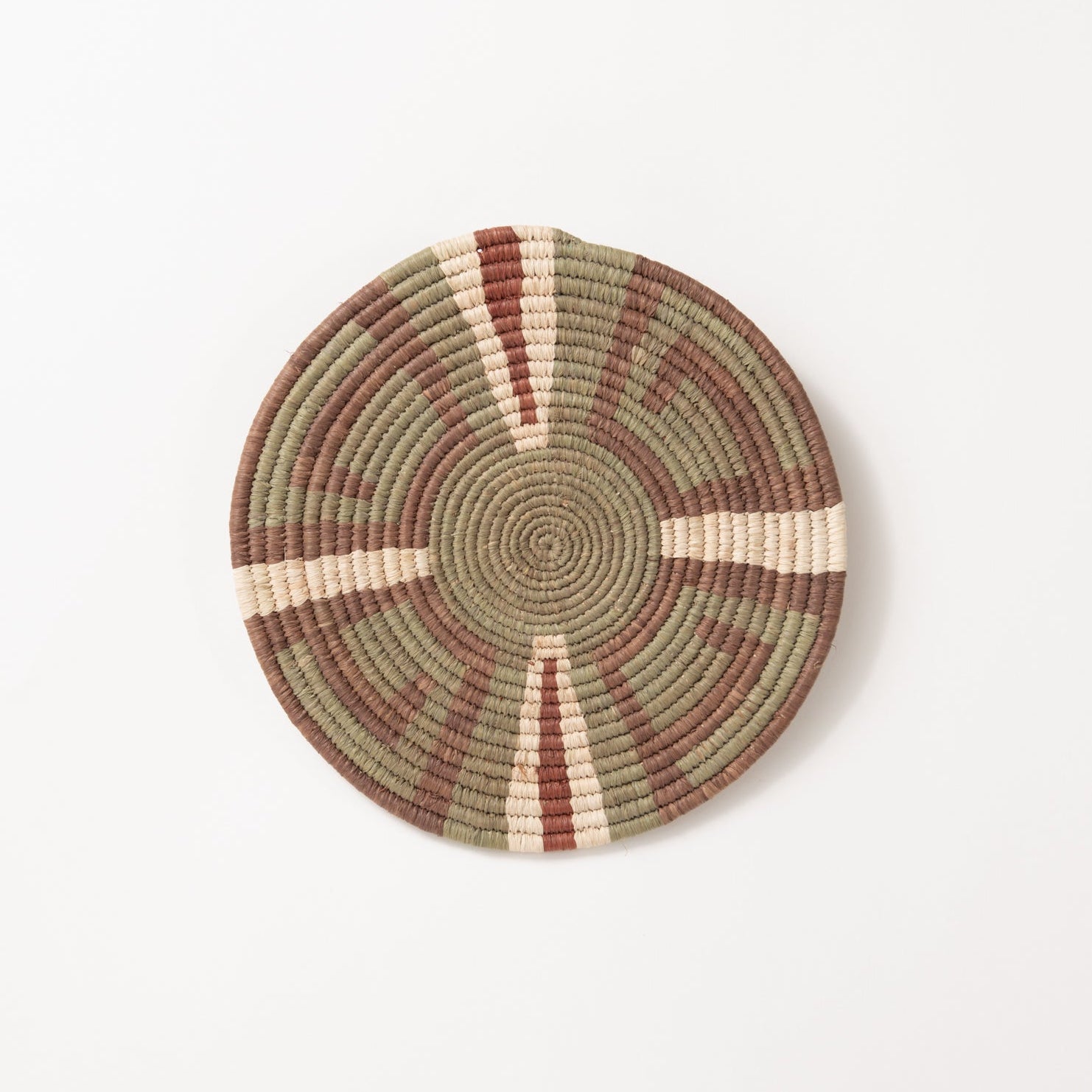 Round woven mat trivet with concentric circle pattern on a white background