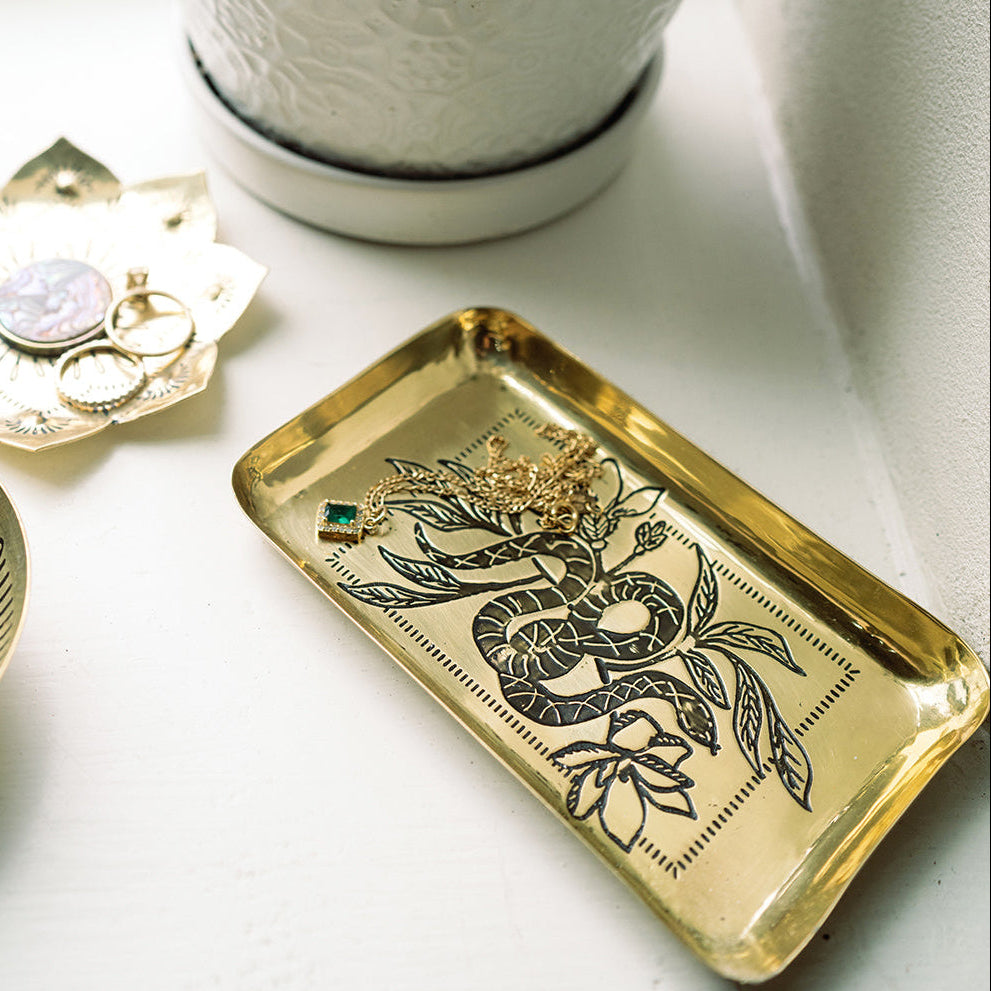 Gold tray with dragon design on a white surface