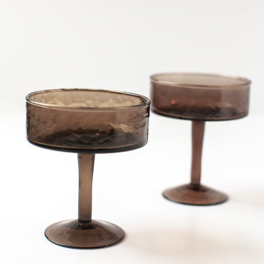 Two smoked handmade cocktail glasses on a white background