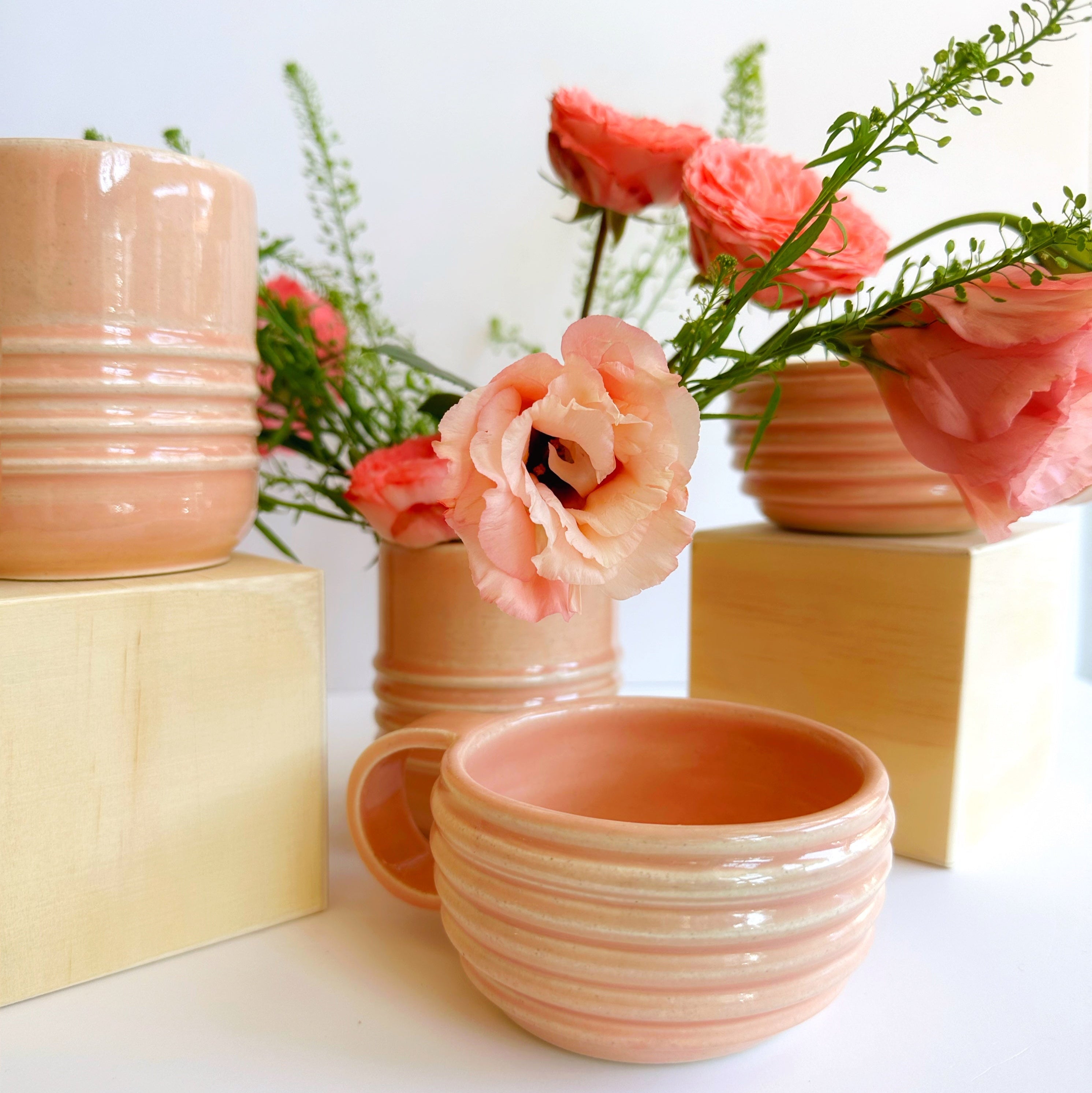 Ceramic pots with floral arrangements on a white background