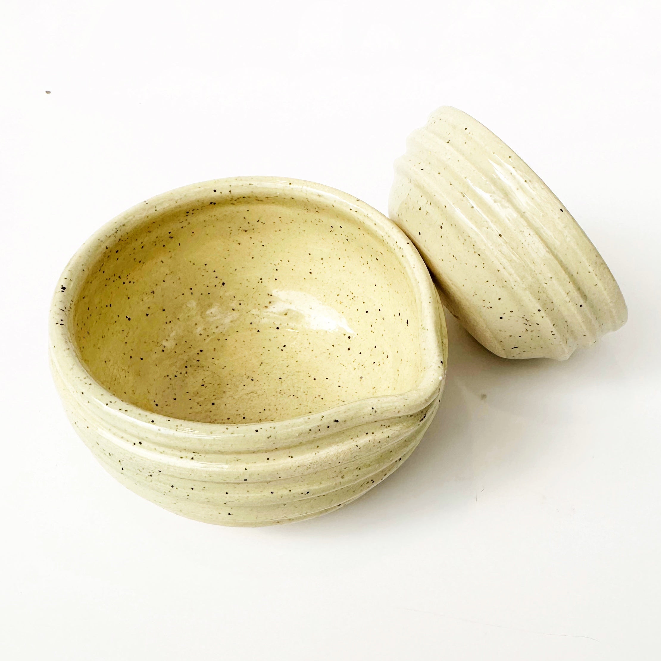 Two ceramic bowls with speckled texture on a white background