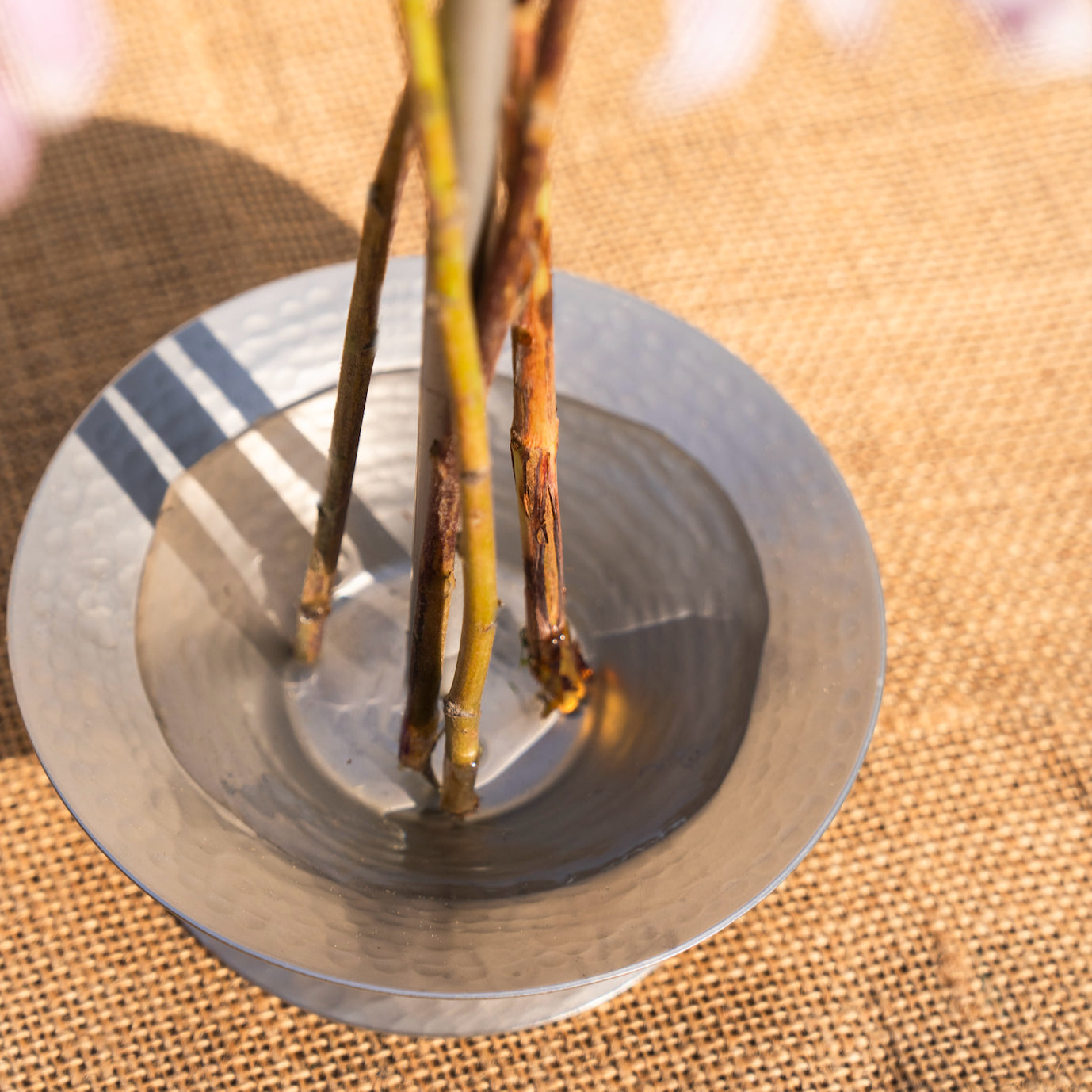 Metallic object with sticks on a textured surface