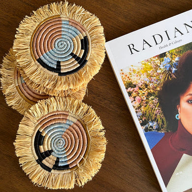 Two woven coasters on a wooden surface with a magazine in the background.