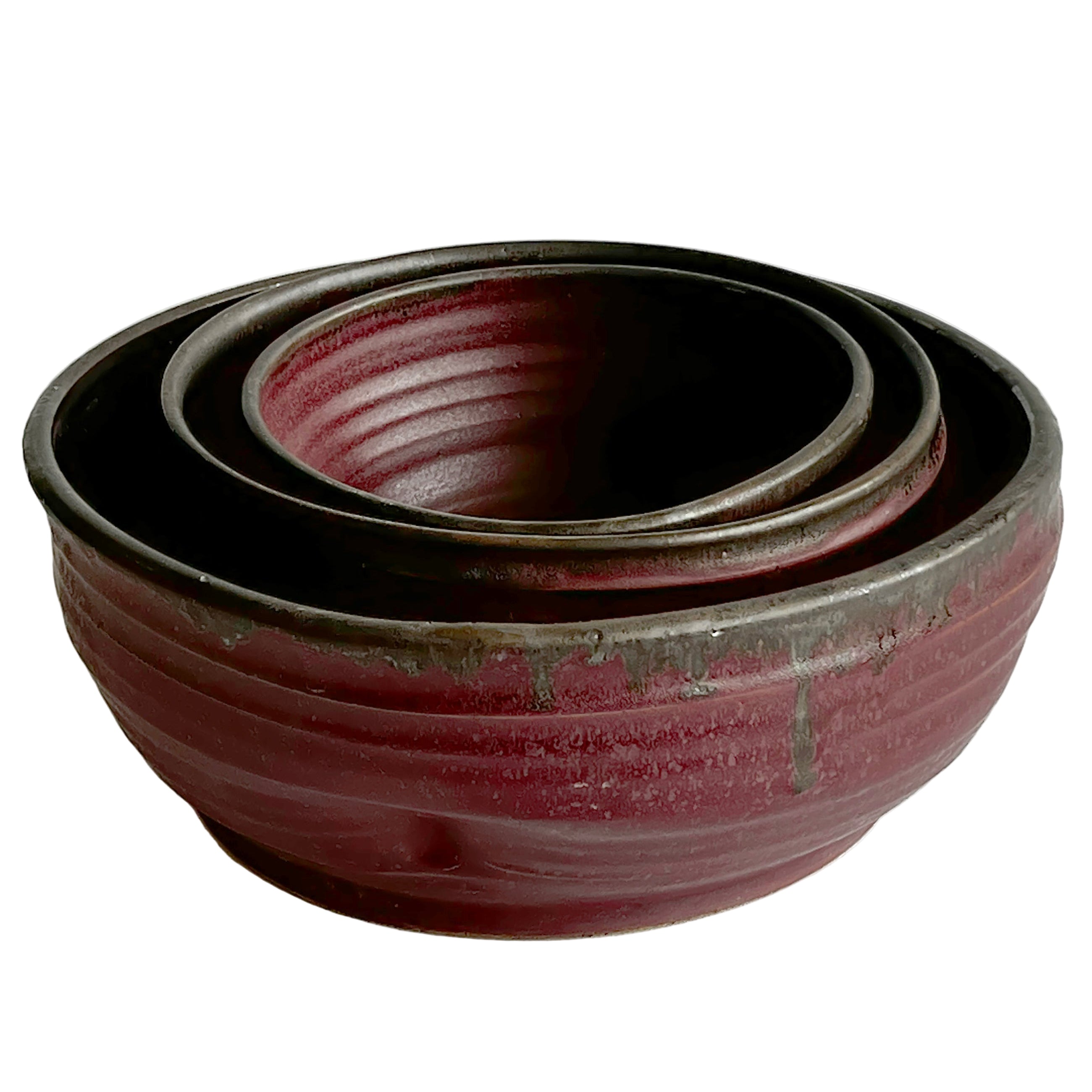 Set of three red ceramic bowls on a white background