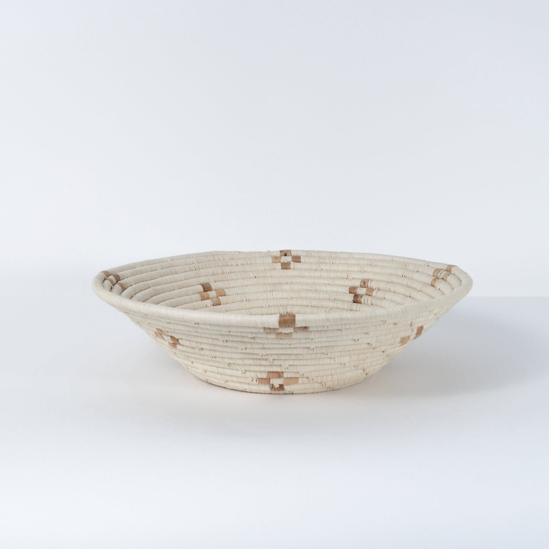 Woven basket with a geometric pattern on a white background