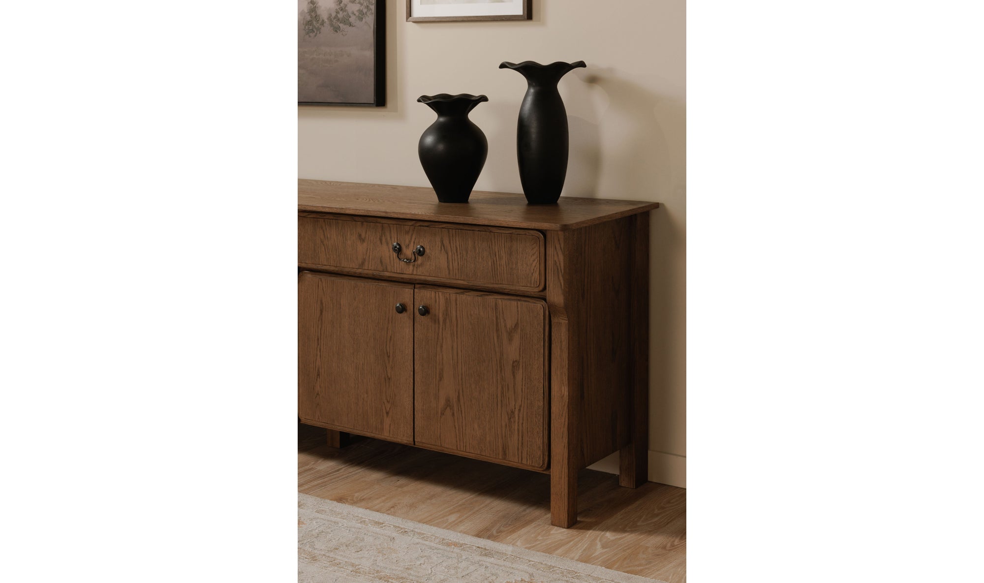 Wooden sideboard with two black vases on a beige wall background