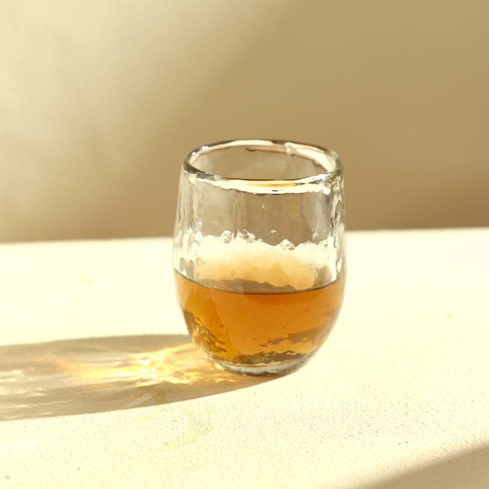 Pebbled cocktail glass with amber-colored drink 