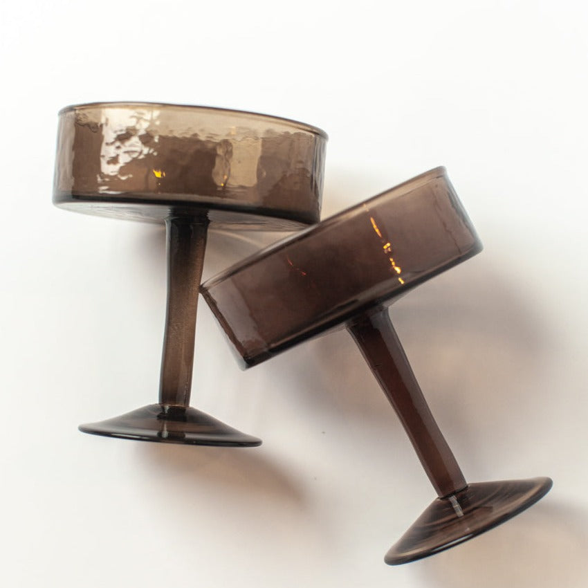 Two brown cocktail glasses on a white background