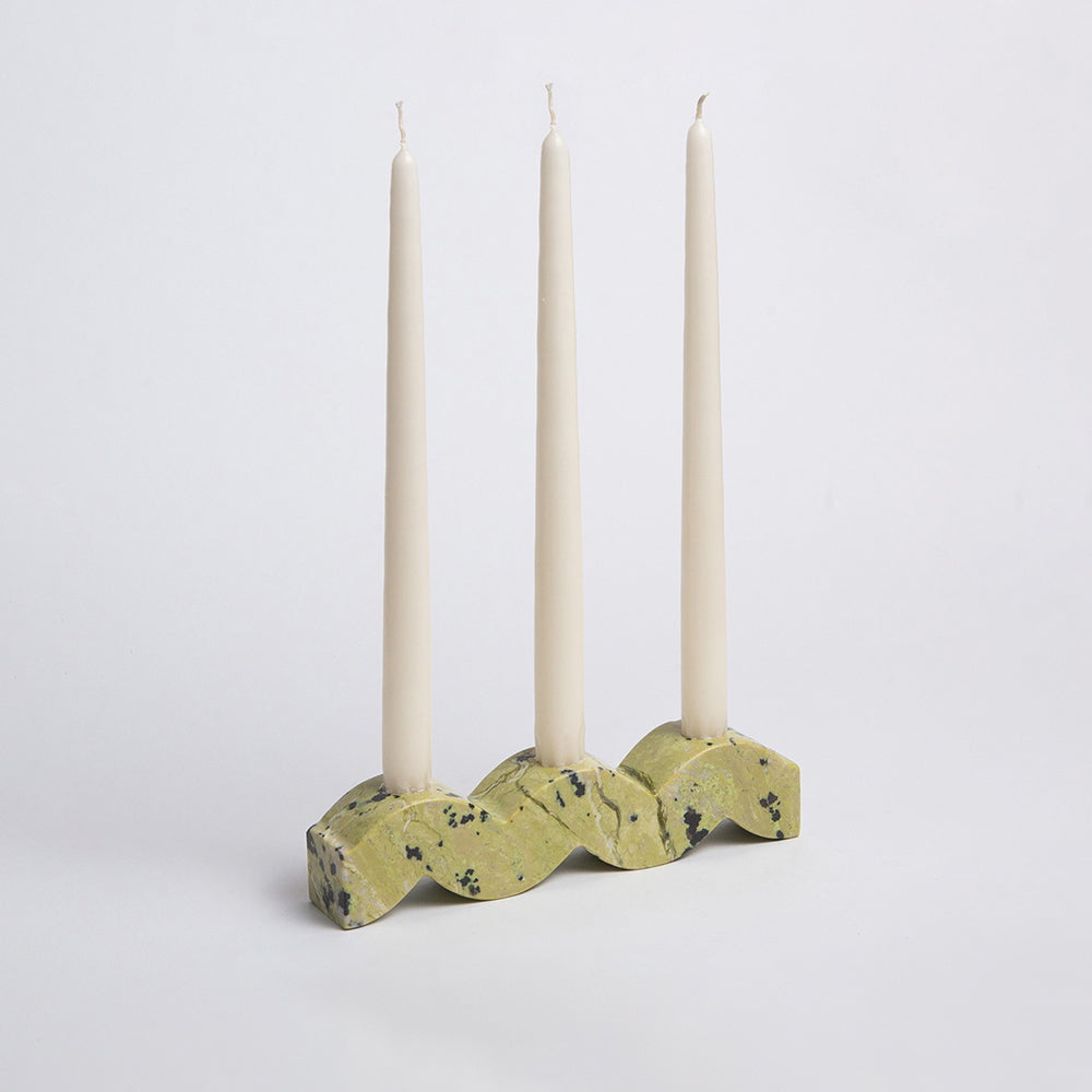 Candle holder with three candles on a white background