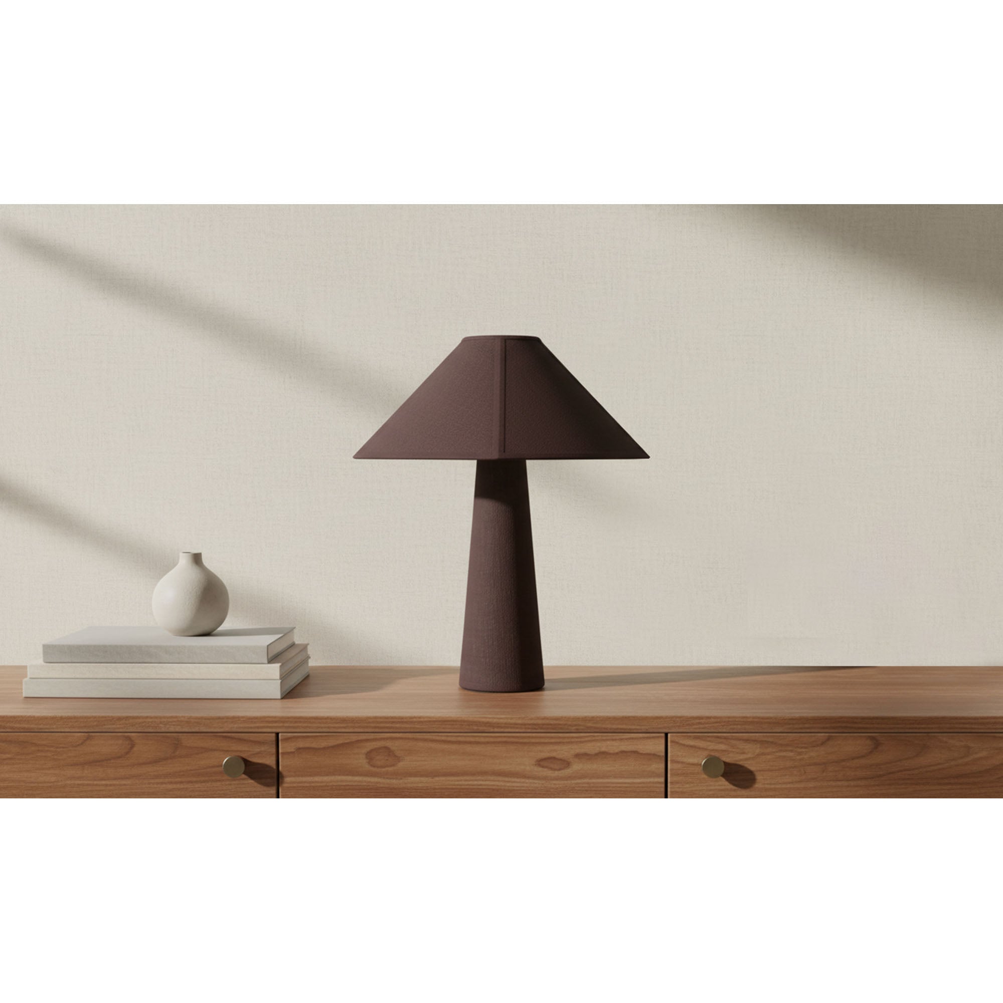 Brown fabric-wrapped table lamp on a wooden sideboard