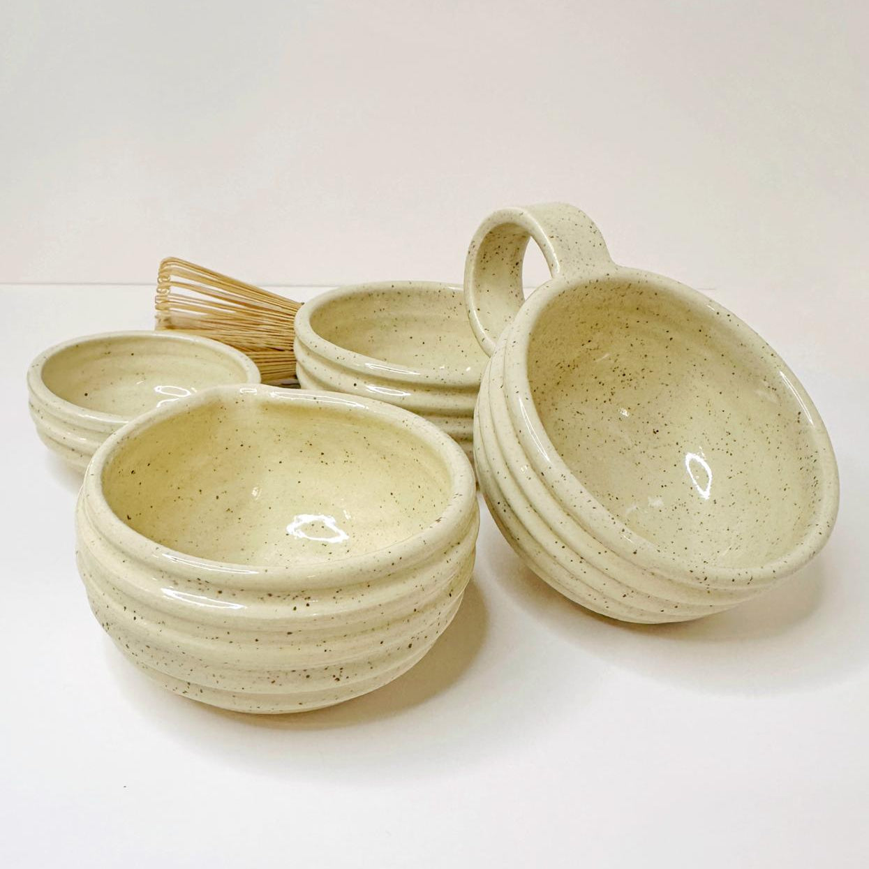 Set of ceramic bowls with handles on a white background