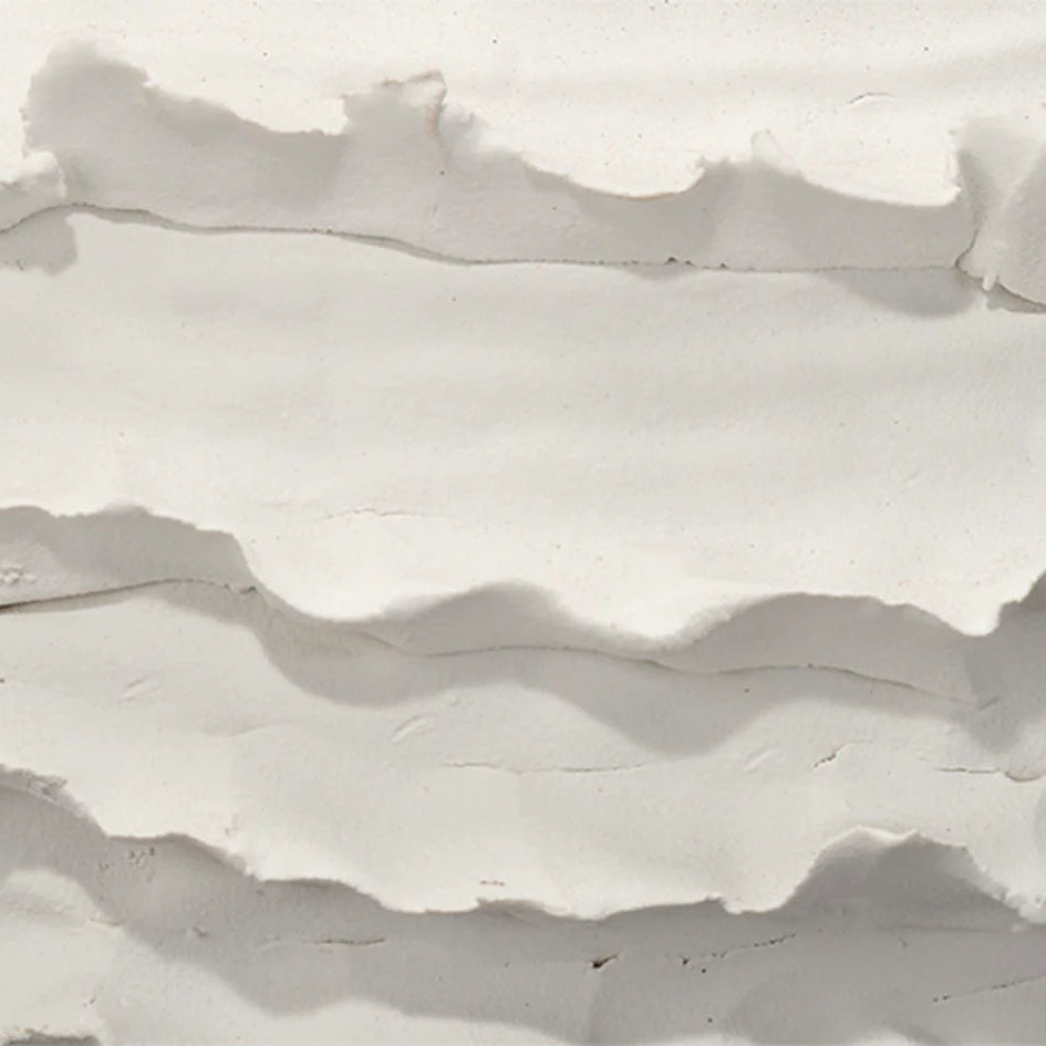 Close-up of a white ruffled ceramic vase