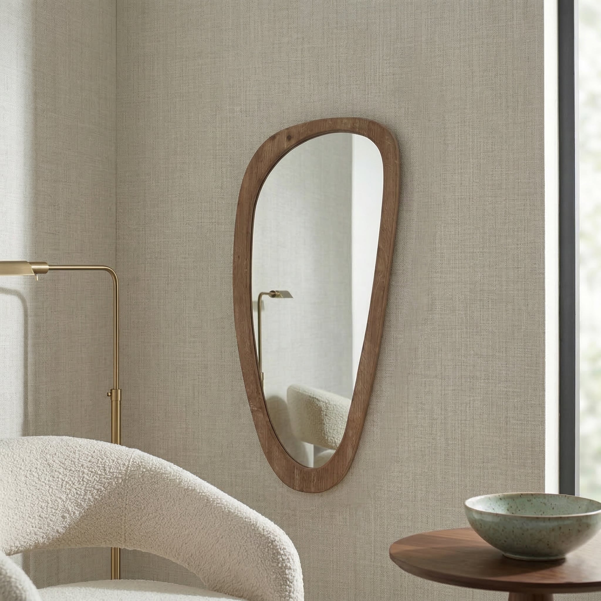 Wooden mirror on a textured wall with a chair and table in the foreground