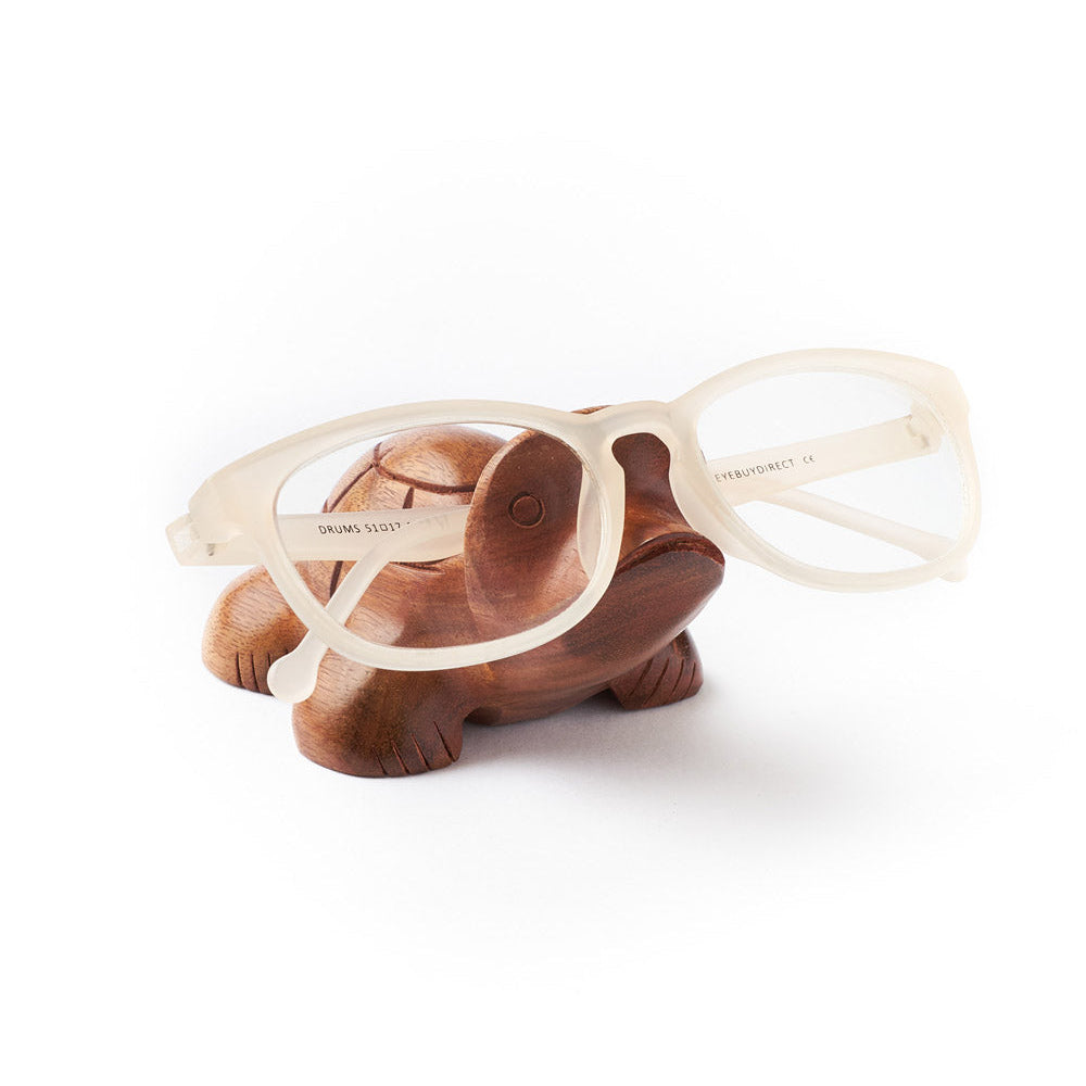 Wooden turtle-shaped eyeglass holder with glasses on a white background