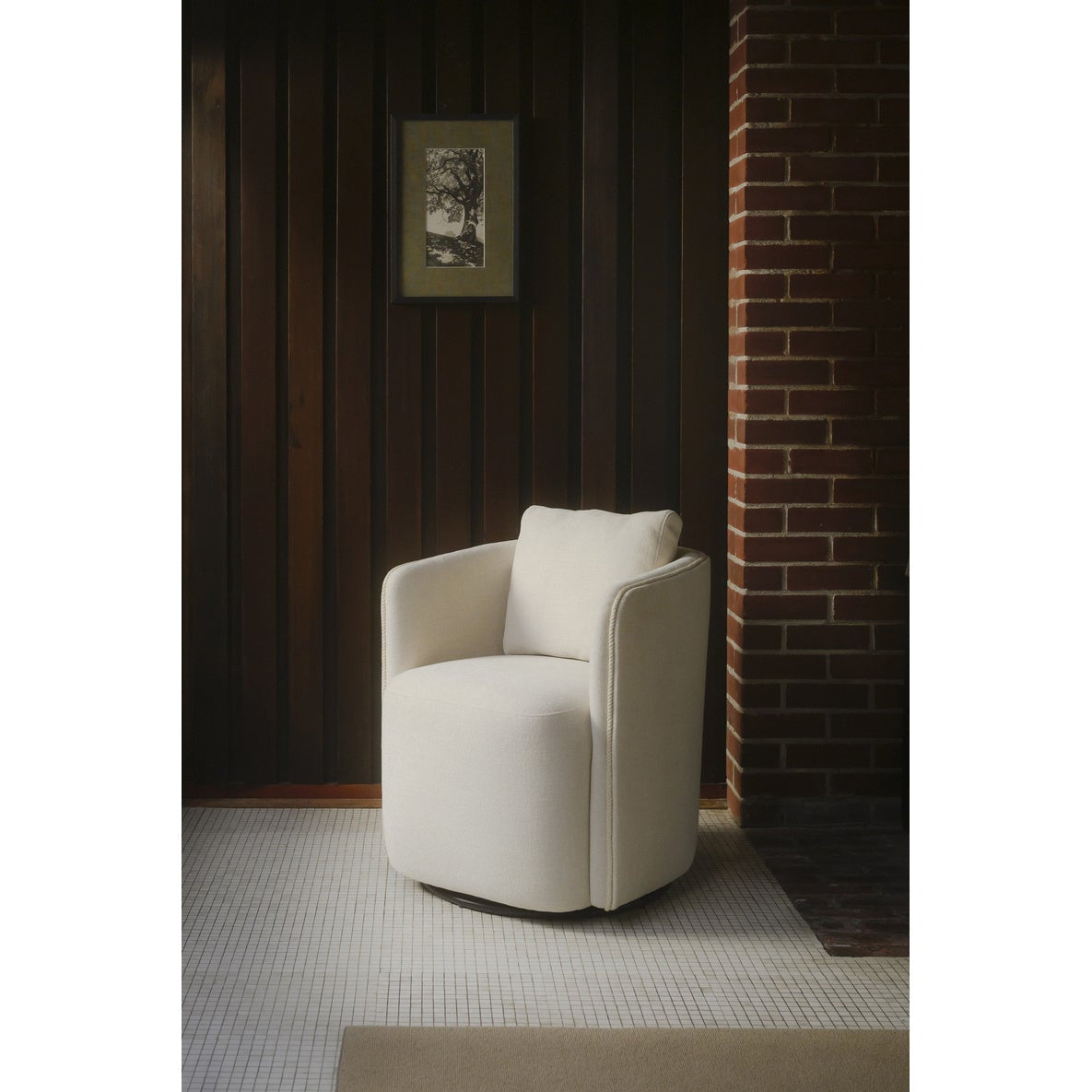 White armchair in a room with wooden walls and a brick wall.