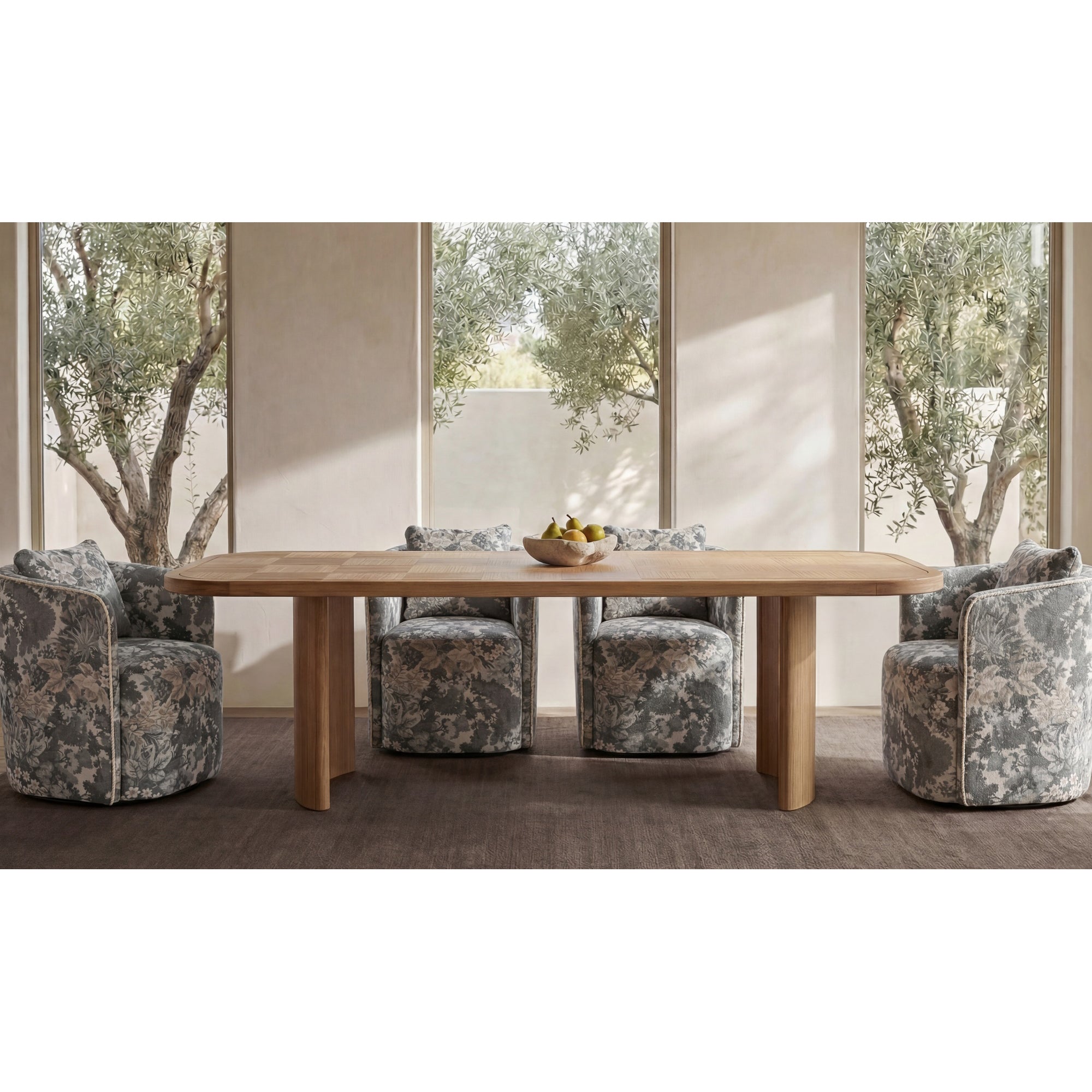 Dining room with a wooden table and patterned chairs in front of large windows.