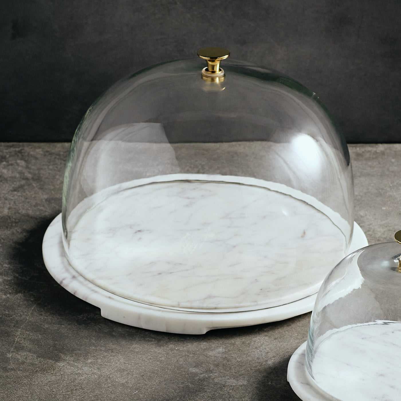 Glass dome with marble base on a dark surface
