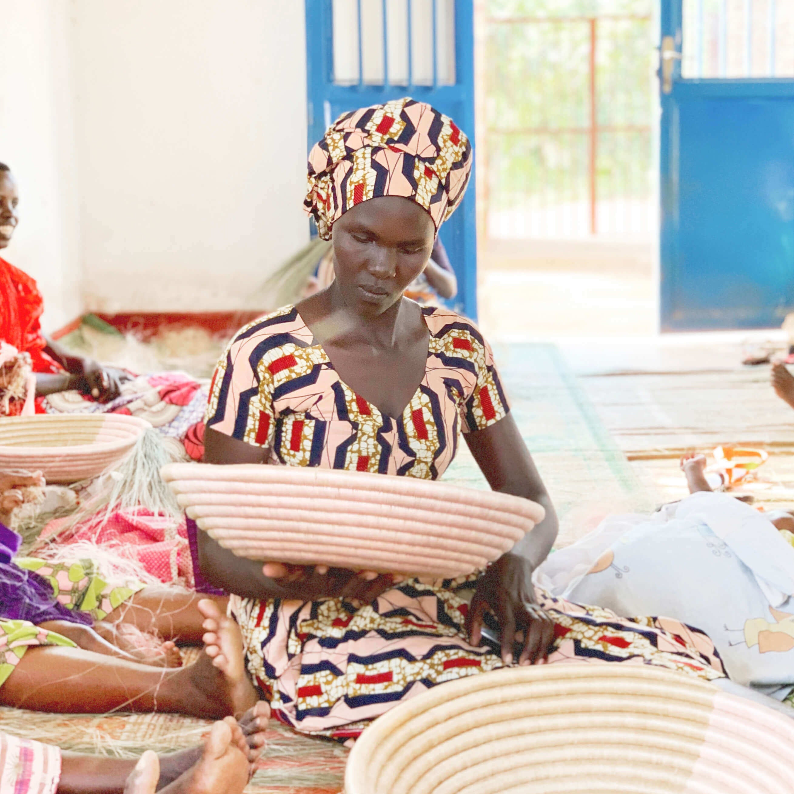 Woman working with woven baskets in a bright room