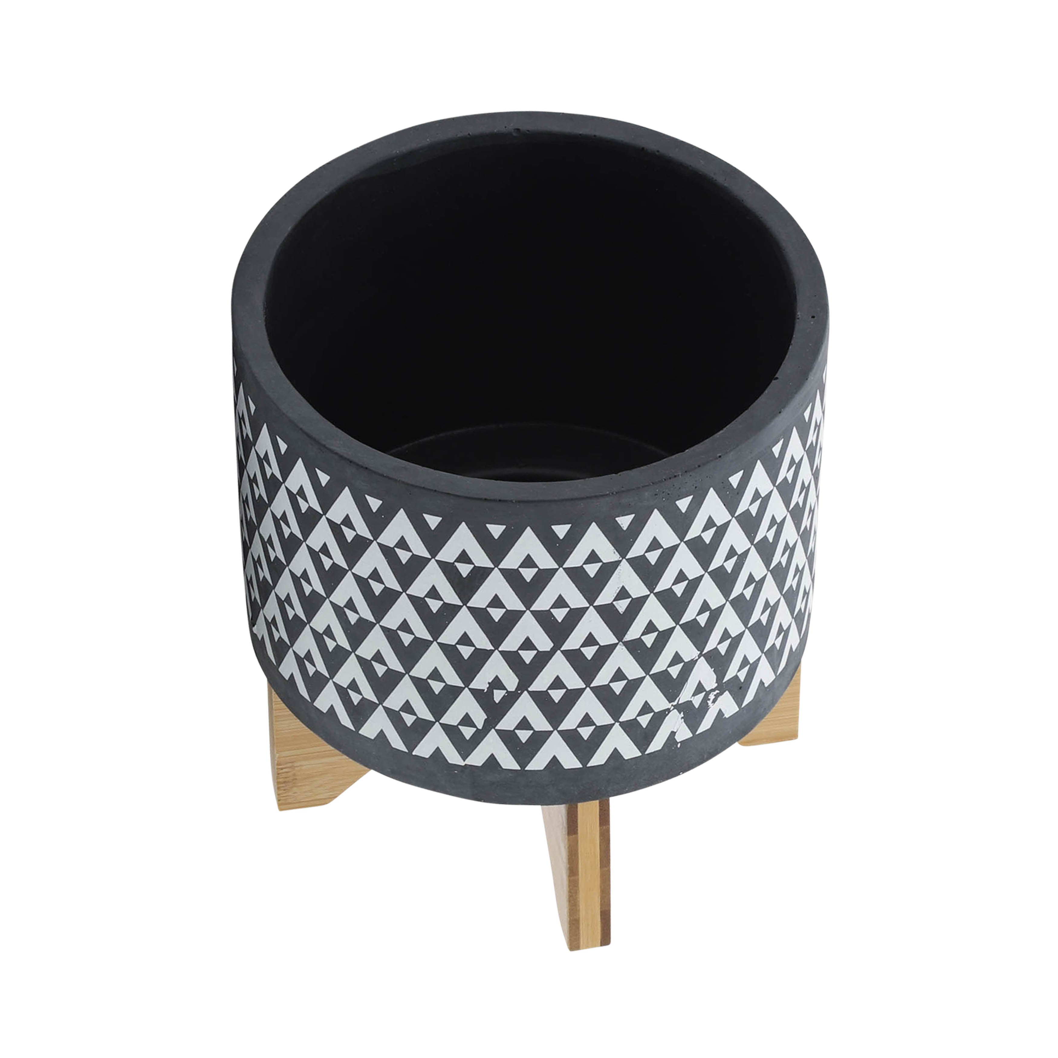 Black patterned planter with wooden legs on a white background