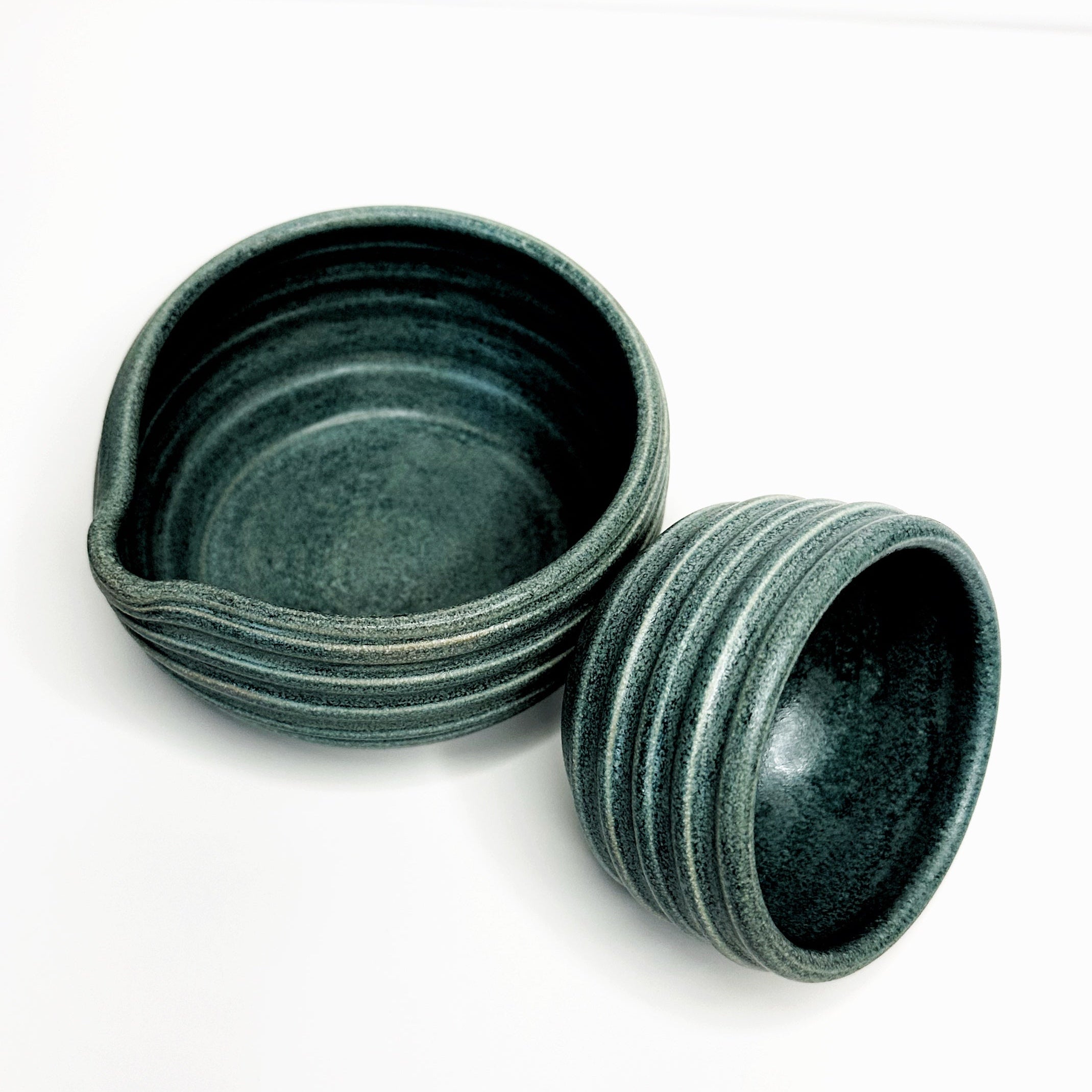 Two green ceramic bowls on a white background