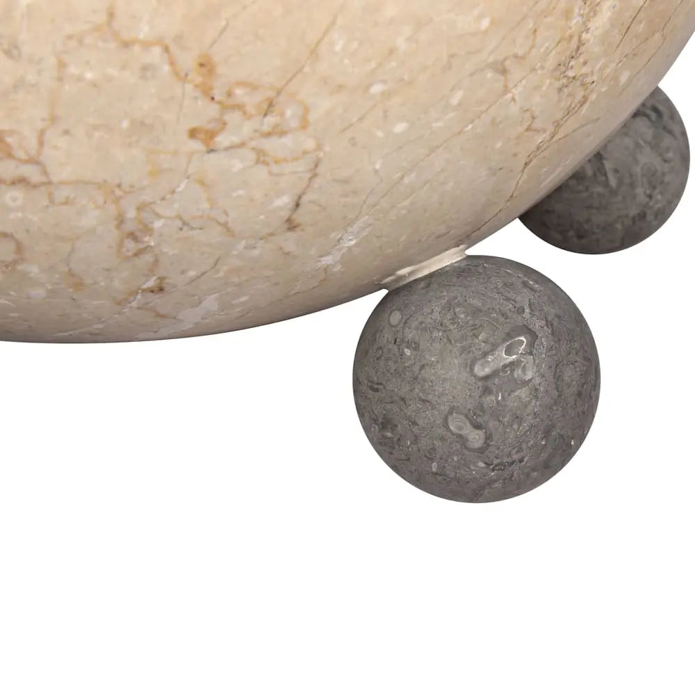 Close-up of stone sphere bowl legs on a white background