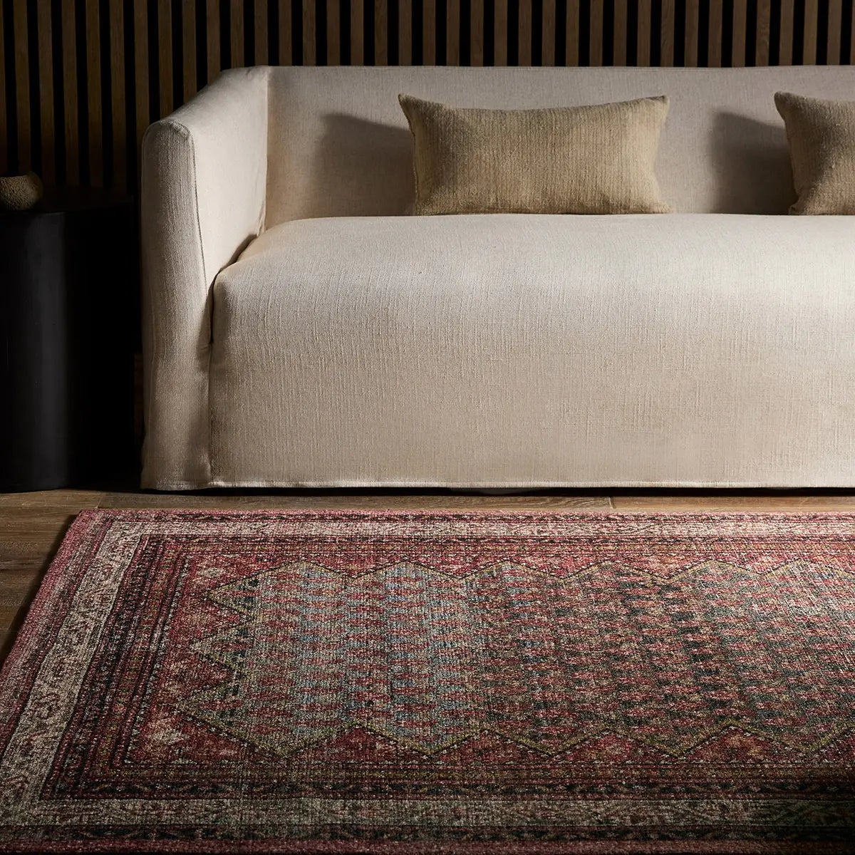 Patterned rug in front of a beige sofa with striped walls