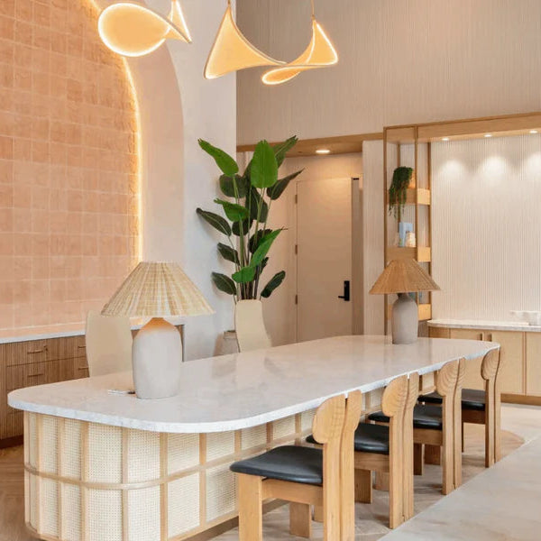 Modern living room with a large window, potted plant, and furniture.