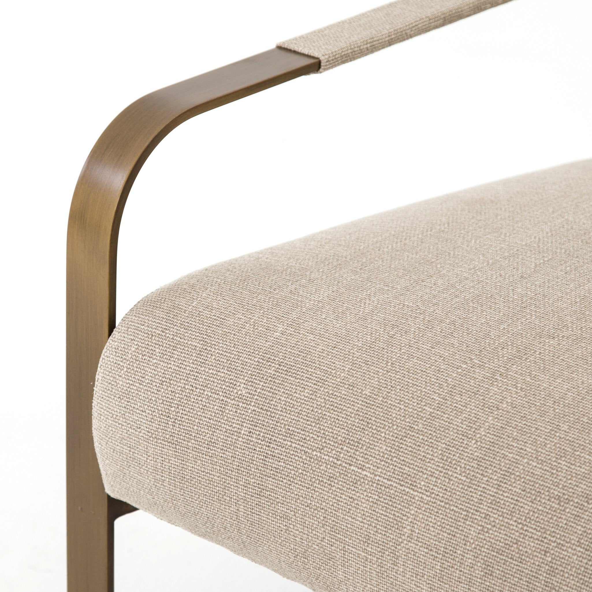 Close-up of a chair with beige cushion and bronze frame on a white background