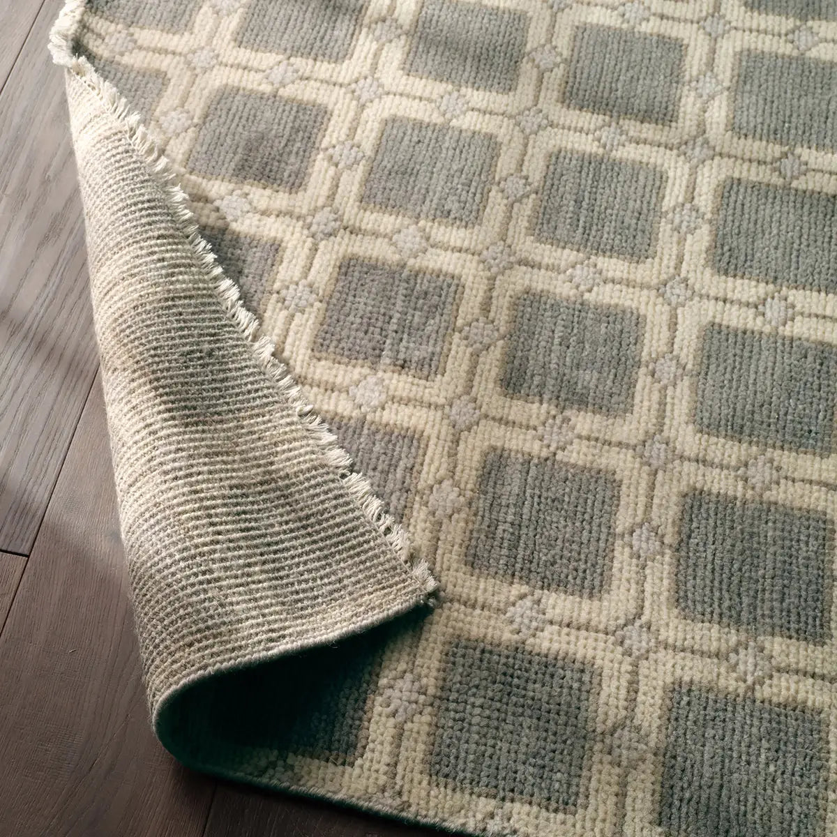 Textured rug with geometric pattern on a wooden floor