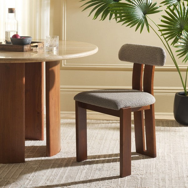 Wooden chair with gray cushion in a room with a table and plant