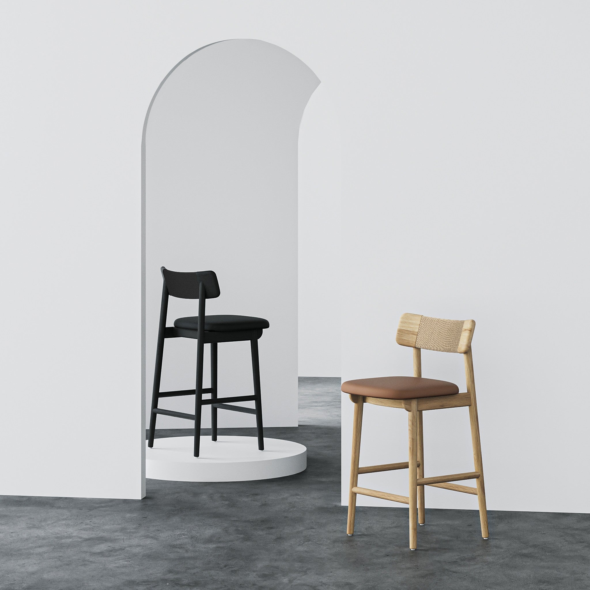 Two modern bar stools in a minimalist studio setting. One stool is black with a black seat and backrest, placed on a white circular platform inside a white arched alcove.