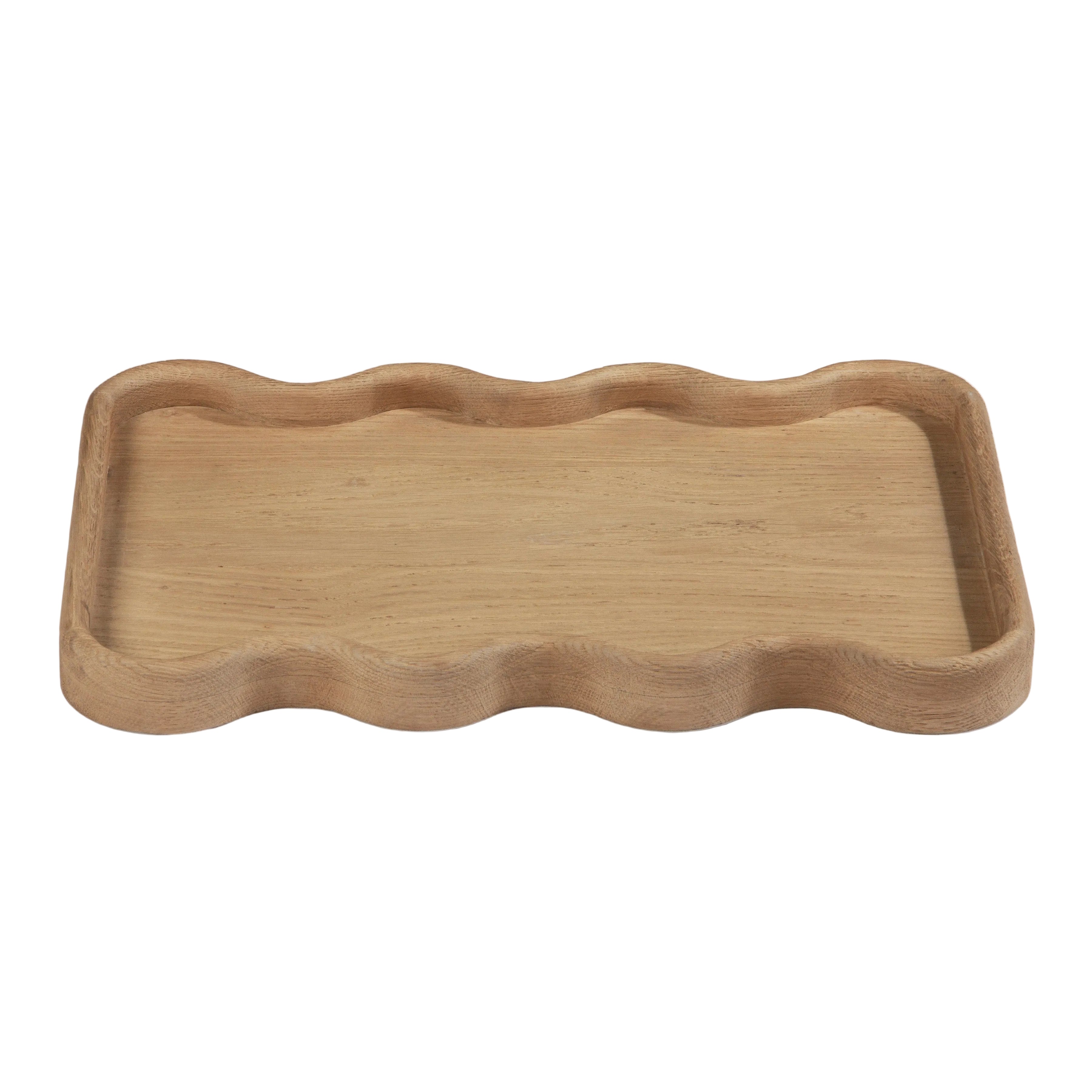 A rectangular wooden serving tray with a wavy, scalloped edge, shown on a clean off-white background.