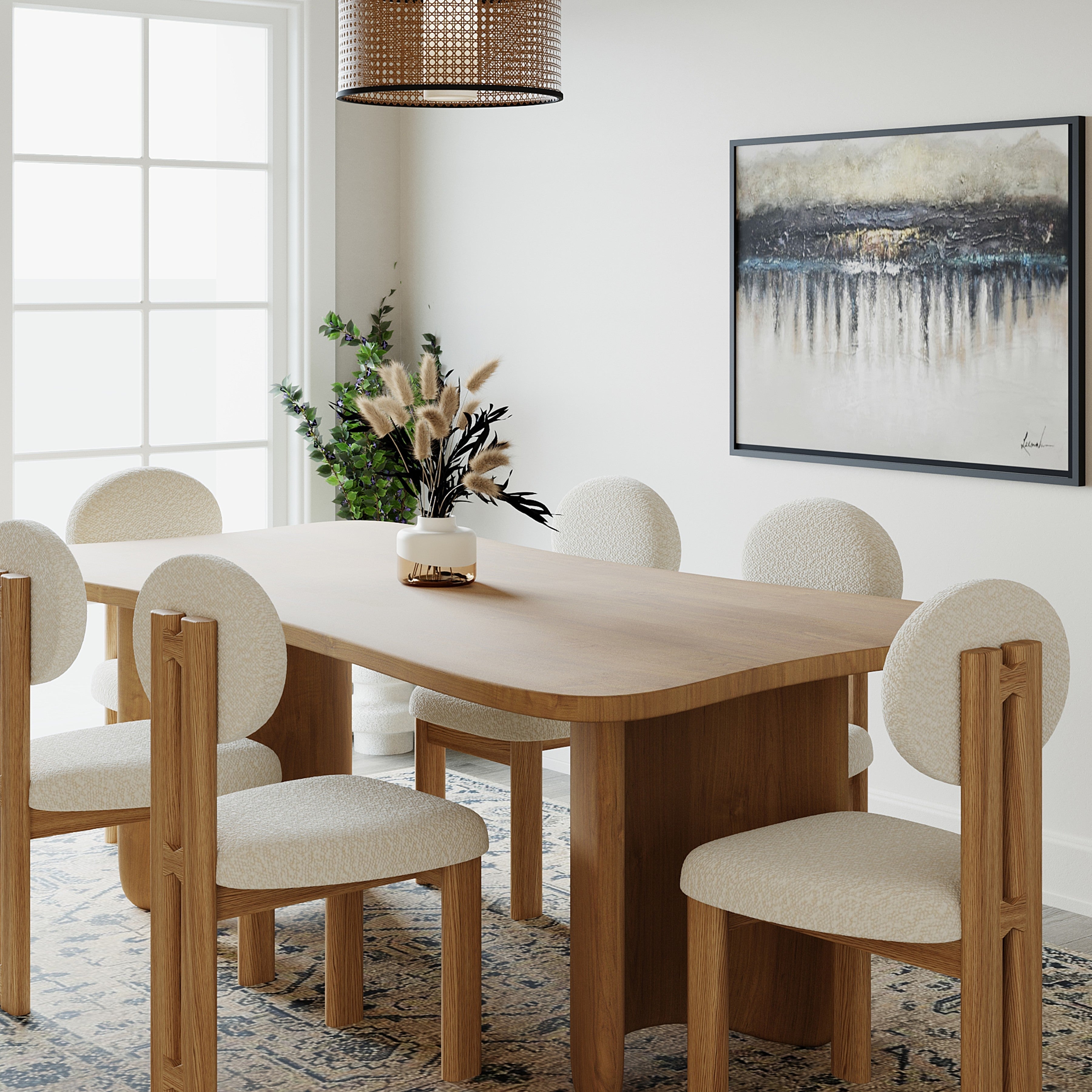 A modern dining room setup featuring a light oak wood dining table with six upholstered chairs in a neutral beige fabric, set on a patterned area rug against a white wall with framed abstract art.