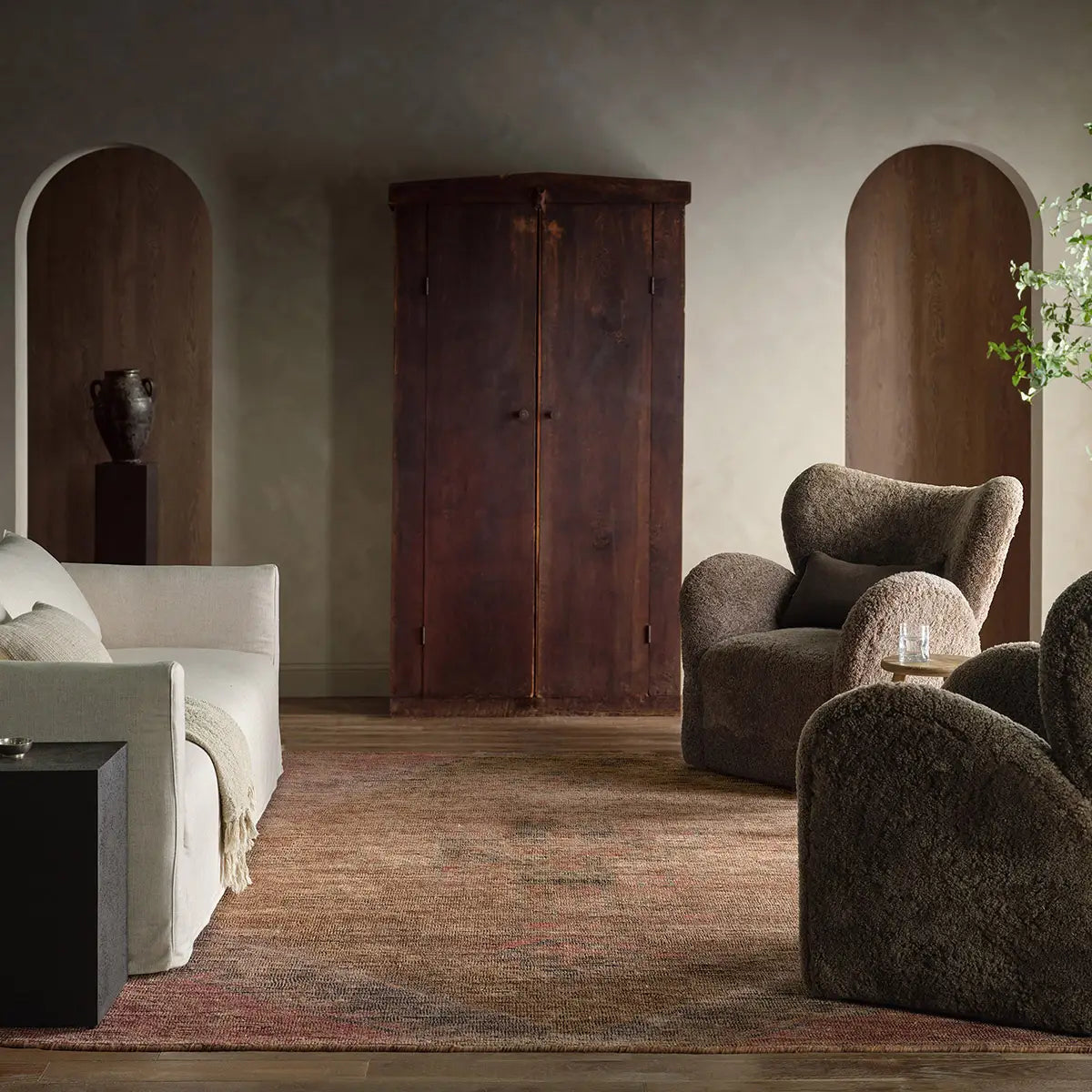 Modern living room with a sofa, armchair, and wooden wardrobe.