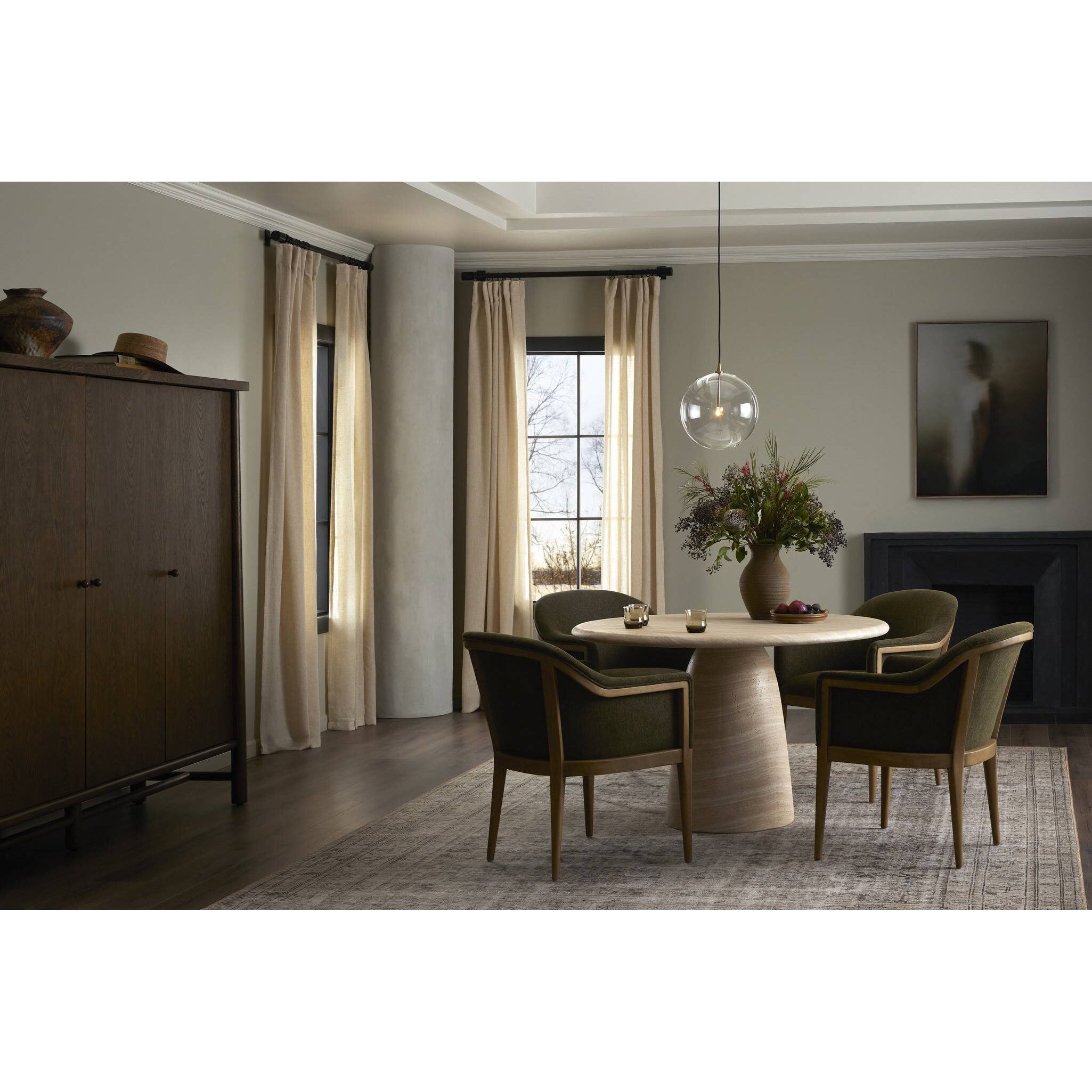 Modern dining room with round table and chairs, large window, and decorative elements.