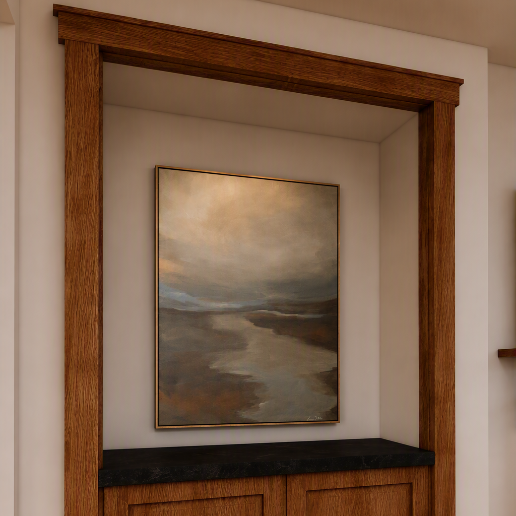 A framed landscape painting of a river or lake under a wooden recessed wall cabinet, shown in a styled interior with a brown leather chair in the foreground.