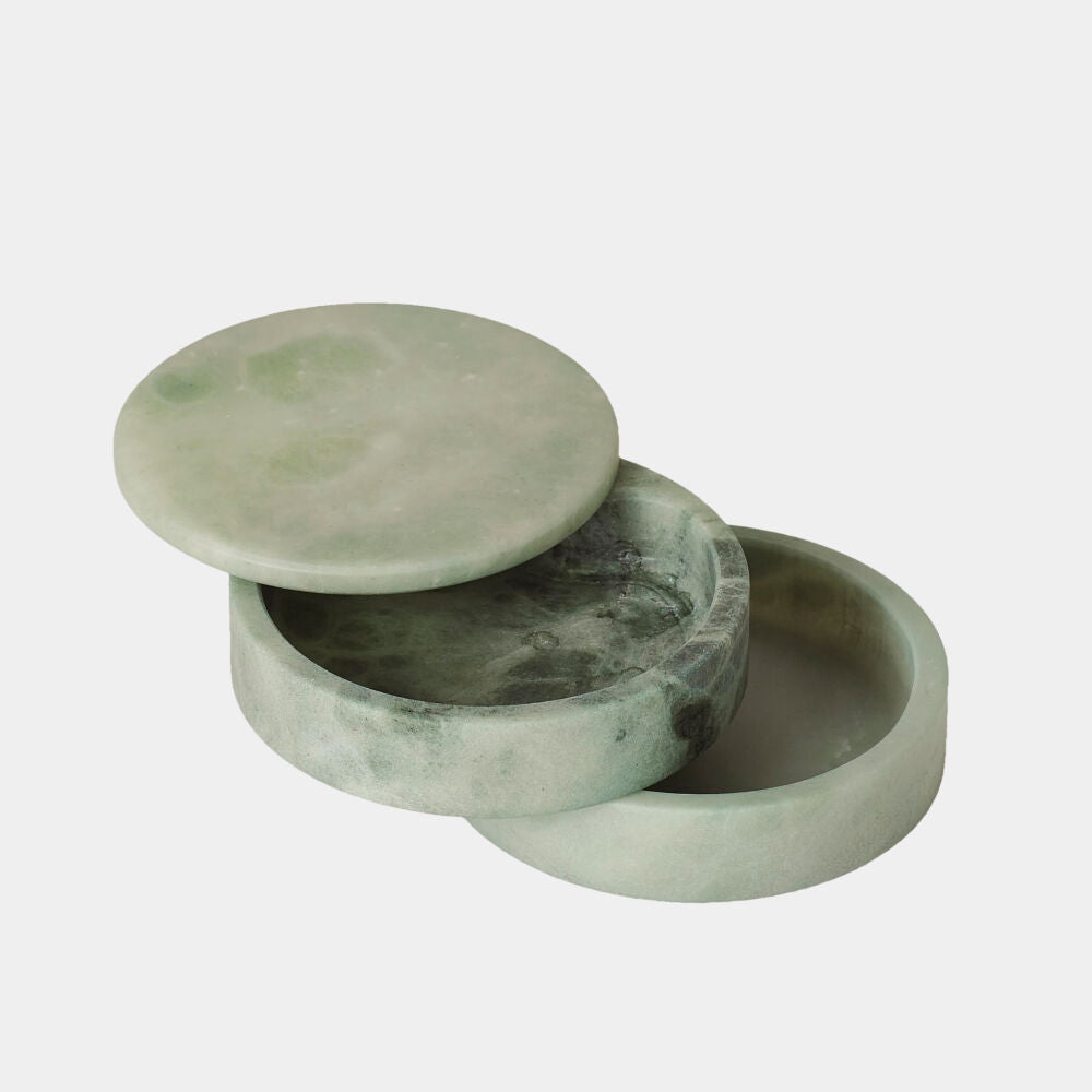Green marble jewelry box with lid open on a light gray background