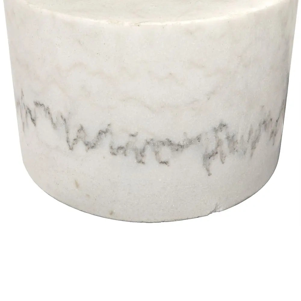 A close-up of a cylindrical white marble container or vase with natural gray veining and a textured, slightly rough surface, shown against a plain white background.