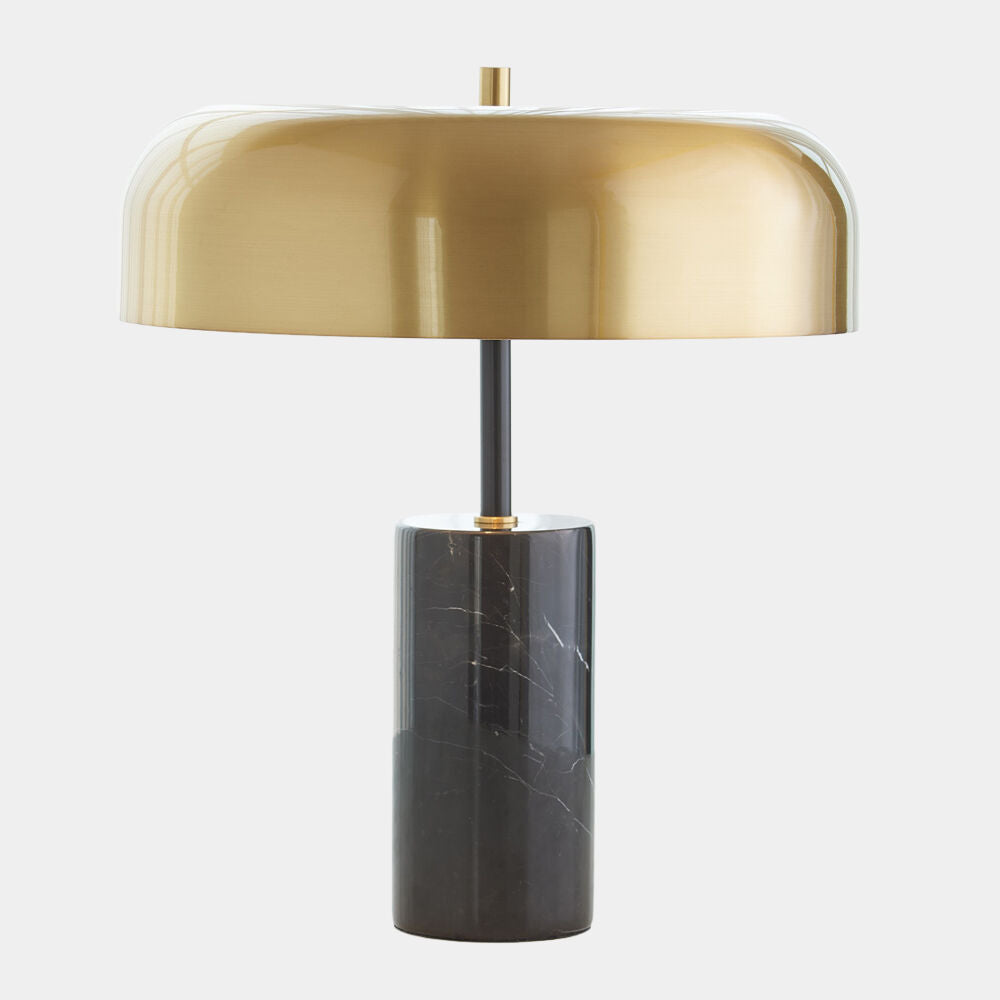 Table lamp with gold shade and black base on a white background