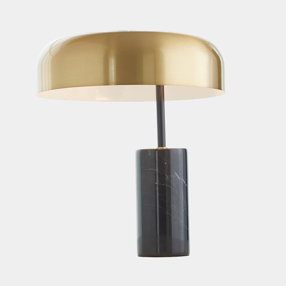 Table lamp with gold shade and black base on a white background