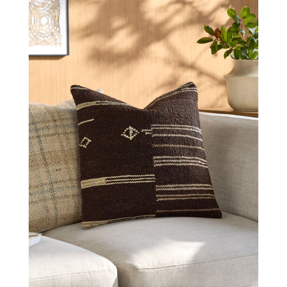 Decorative pillow with brown and beige patterns on a light-colored sofa.
