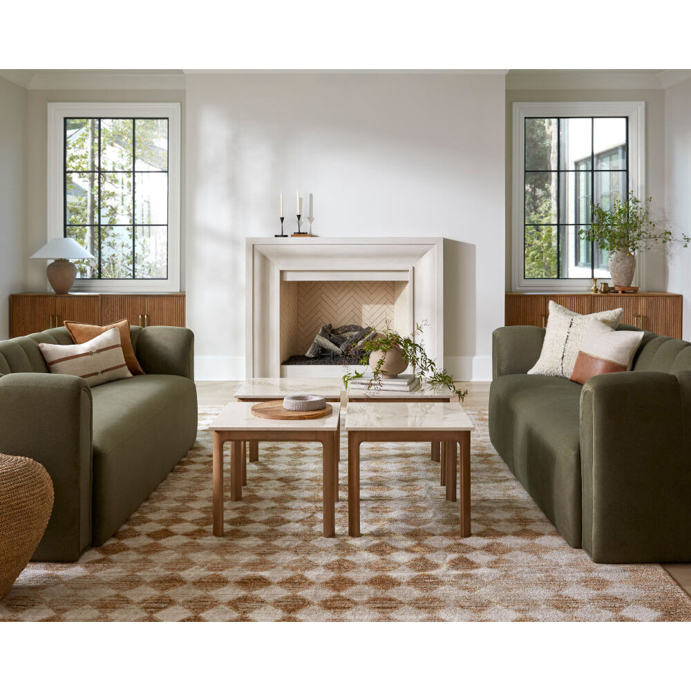 Modern living room with green sofas, a coffee table, and decorative items.