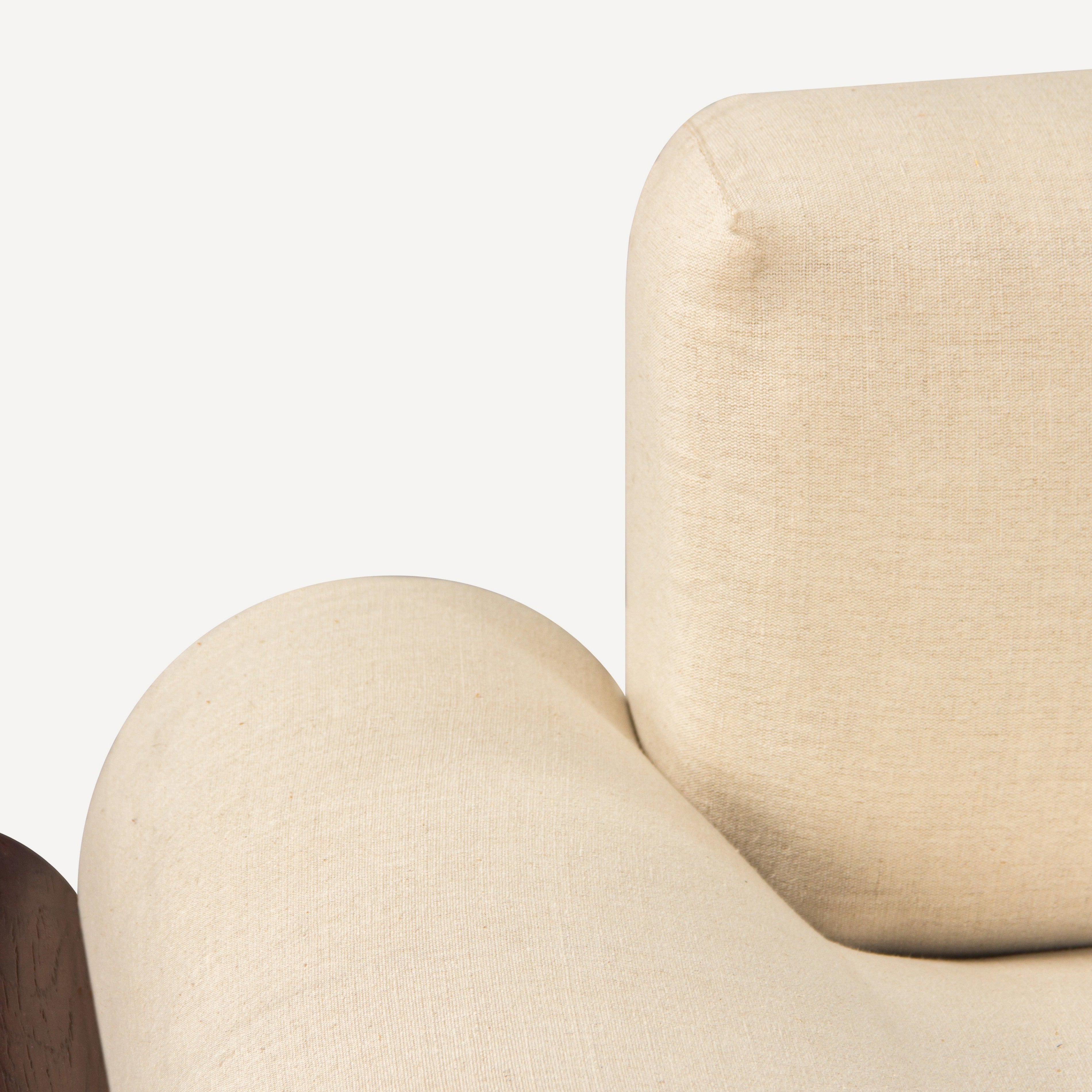 Close-up of a beige upholstered chair with a plain background