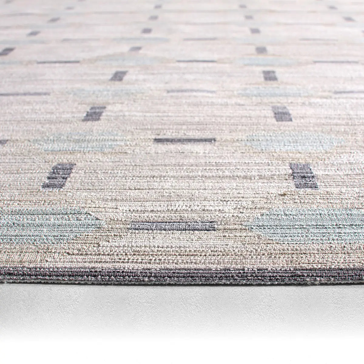 Close-up of a textured rug with geometric pattern on a light background