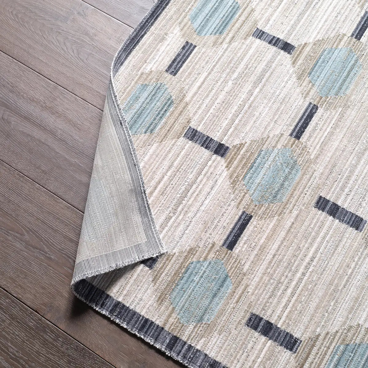 Textured area rug with geometric pattern on wooden floor