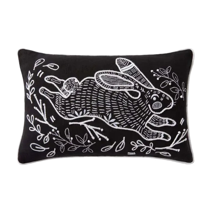 Black pillow with white rabbit design on a white background