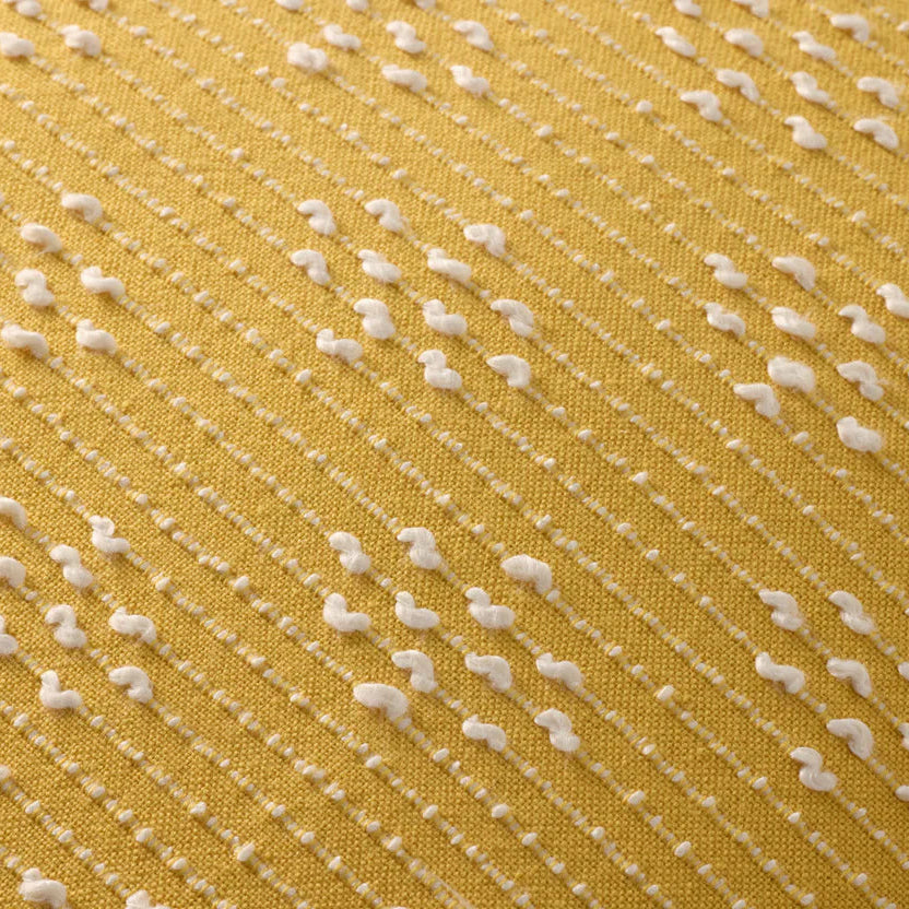 Close-up of a yellow fabric with white thread pattern